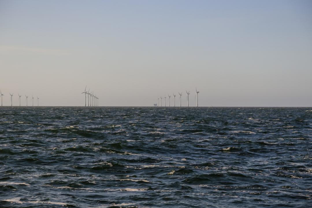 A wind turbine in the distance on the sea