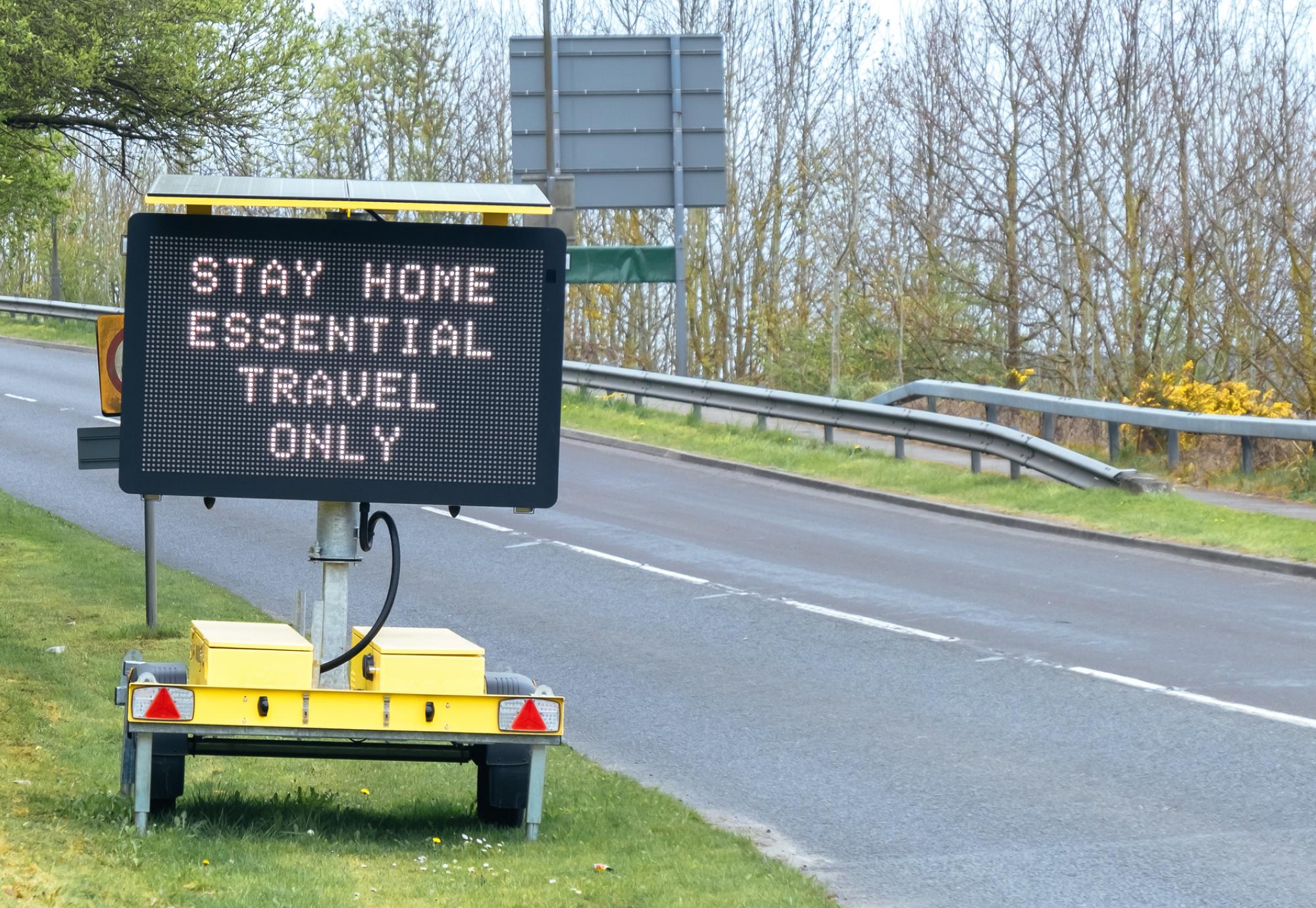 Sign tells motorists to stay at home, essential journeys only. 
