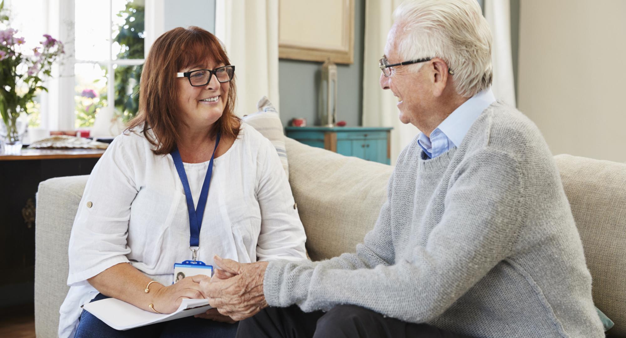 Female social care worker supporting older man