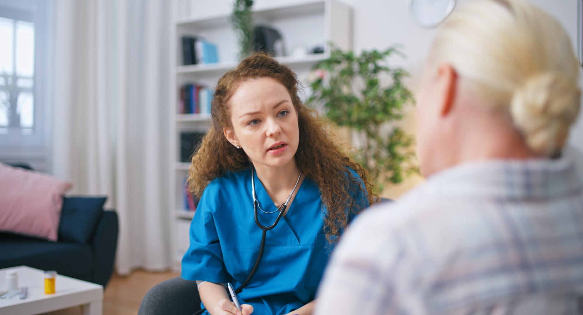 A therapist listens to the patient's complaints, fills out a medical form, and provides home care