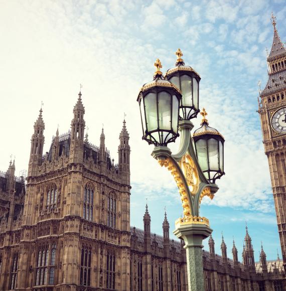Big Ben in London with the houses of parliament and ornate street lamp.