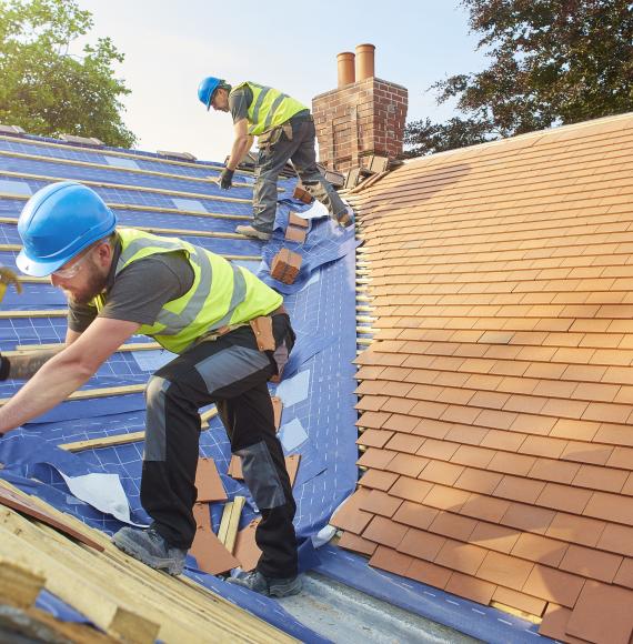 Builders tiling a roof