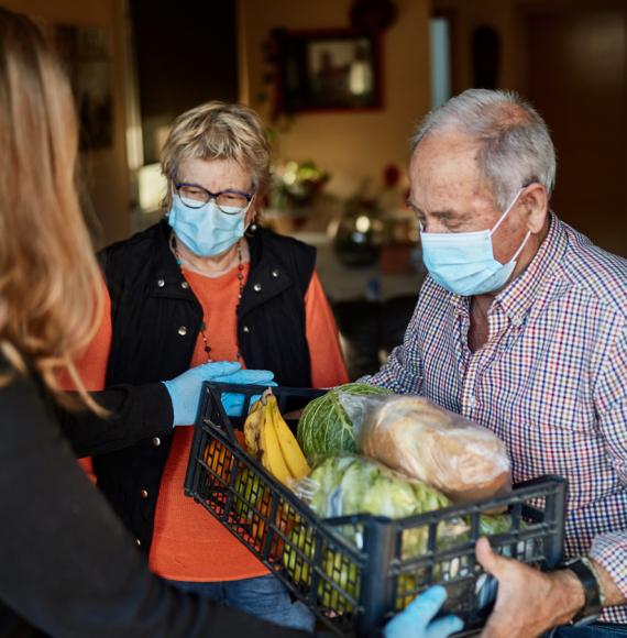 Elderly couple receive food parcel during pandemic. 