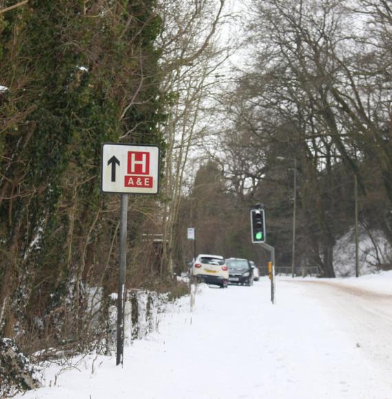 A sign for a hospital on a snowy road