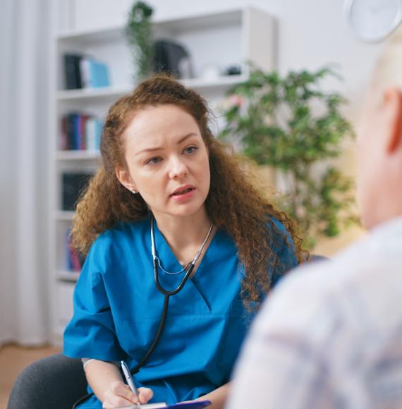 A therapist listens to the patient's complaints, fills out a medical form, and provides home care
