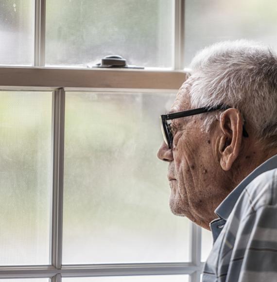 Wistful Senior Man Staring Through Hazy Window