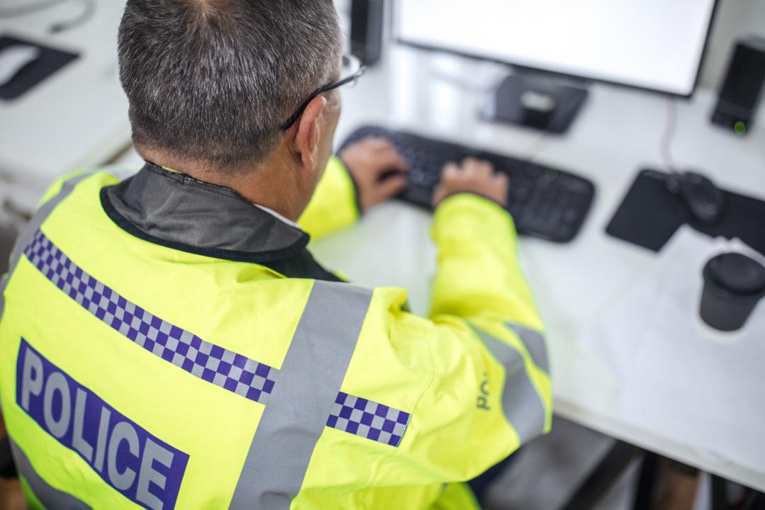 UK Police officer operating a computer