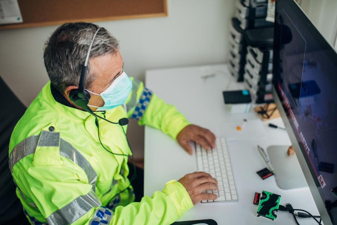 Older police officer operating a computer