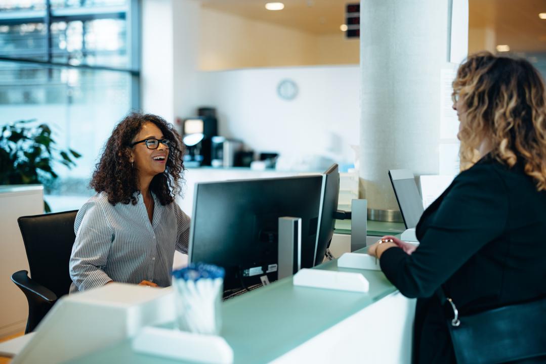 Receptionist speaking to woman
