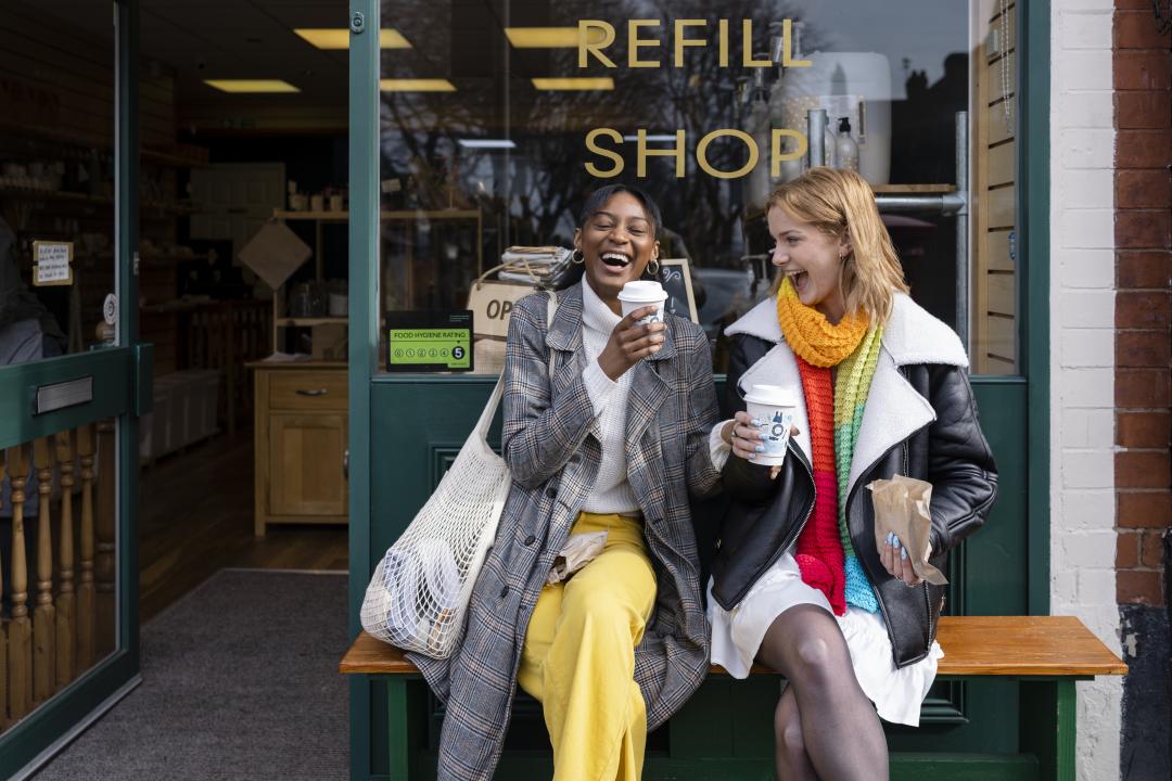 Young people sat outside a shop