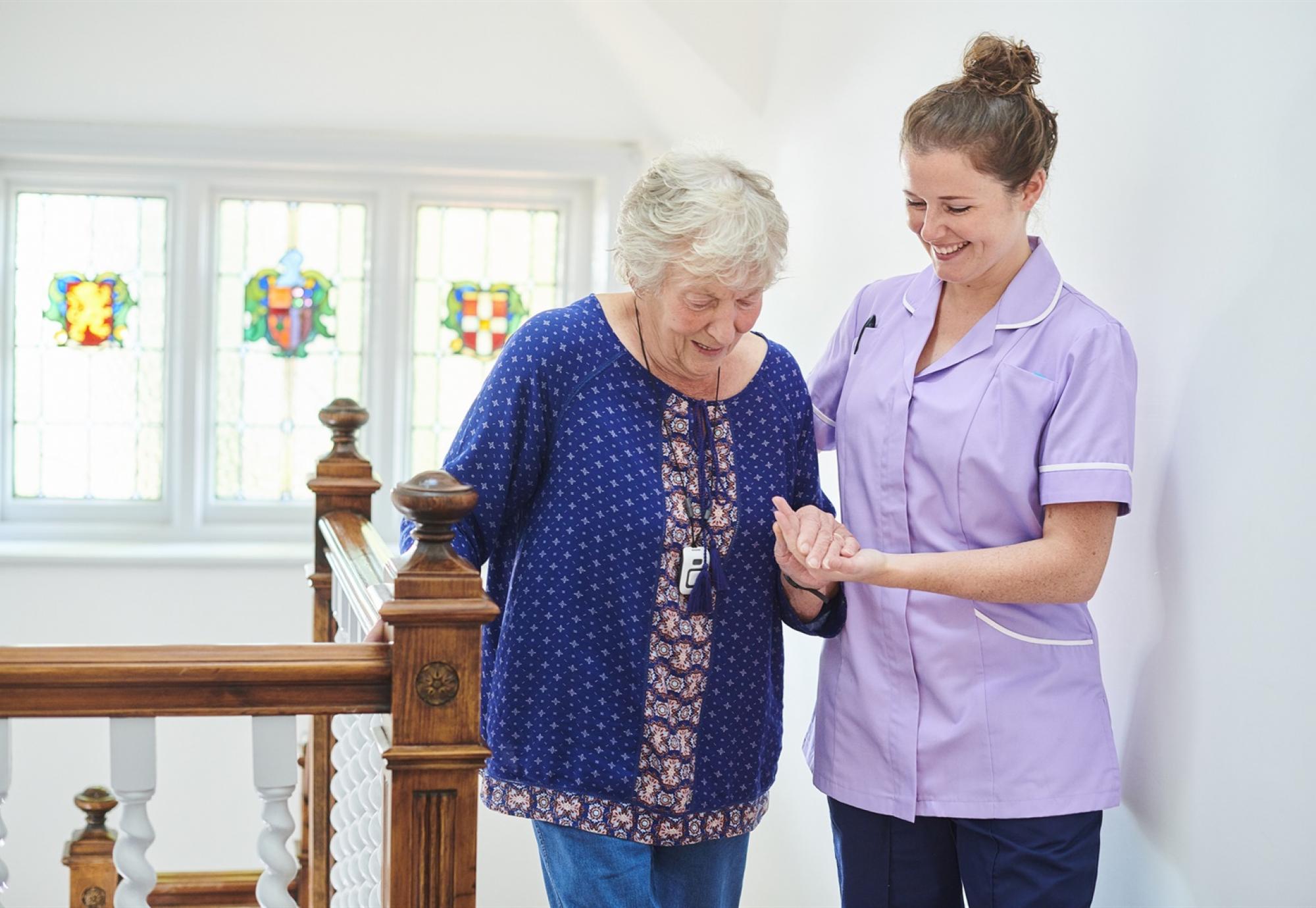 Carer helping elderly woman 