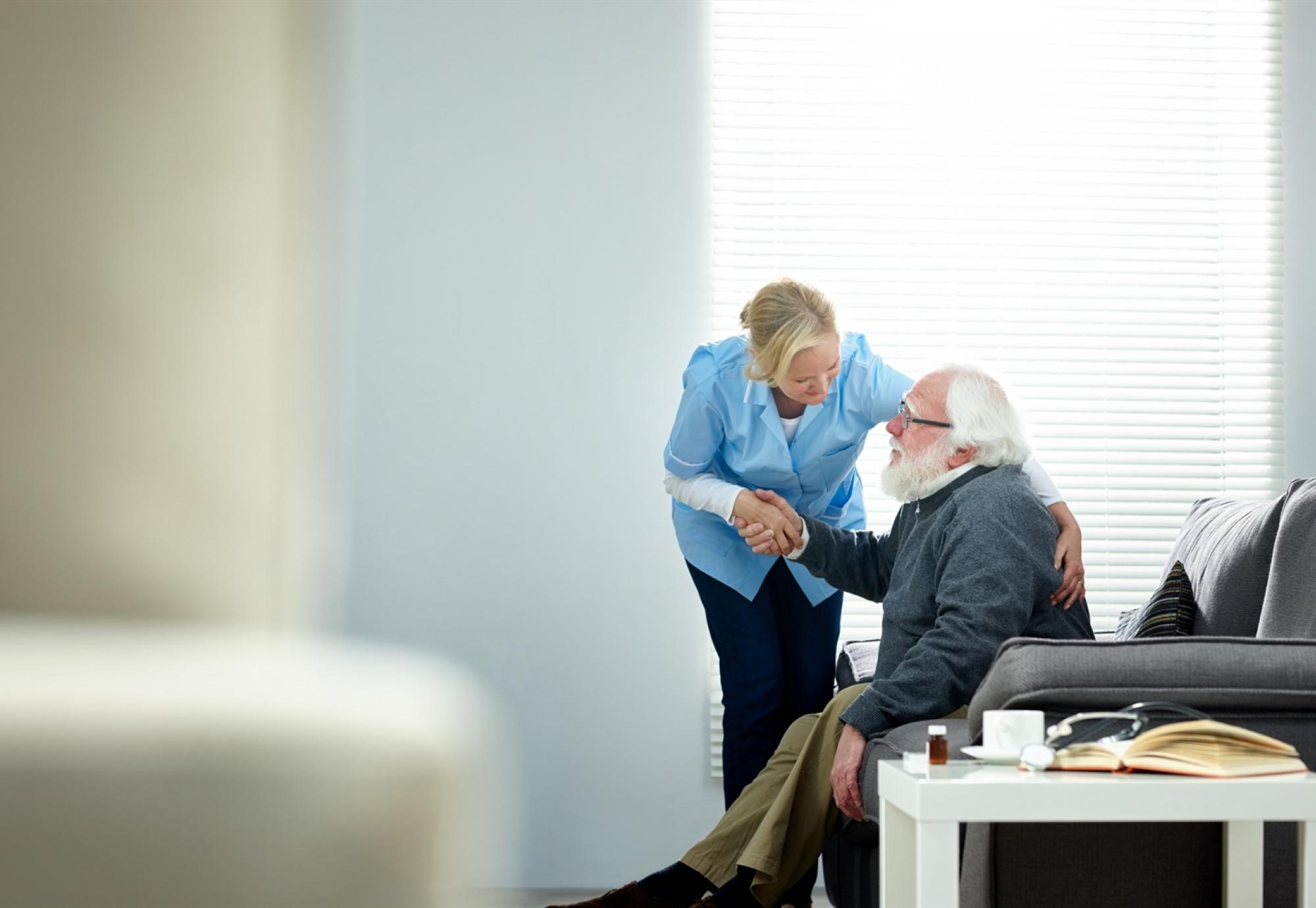 Carer helping elderly man