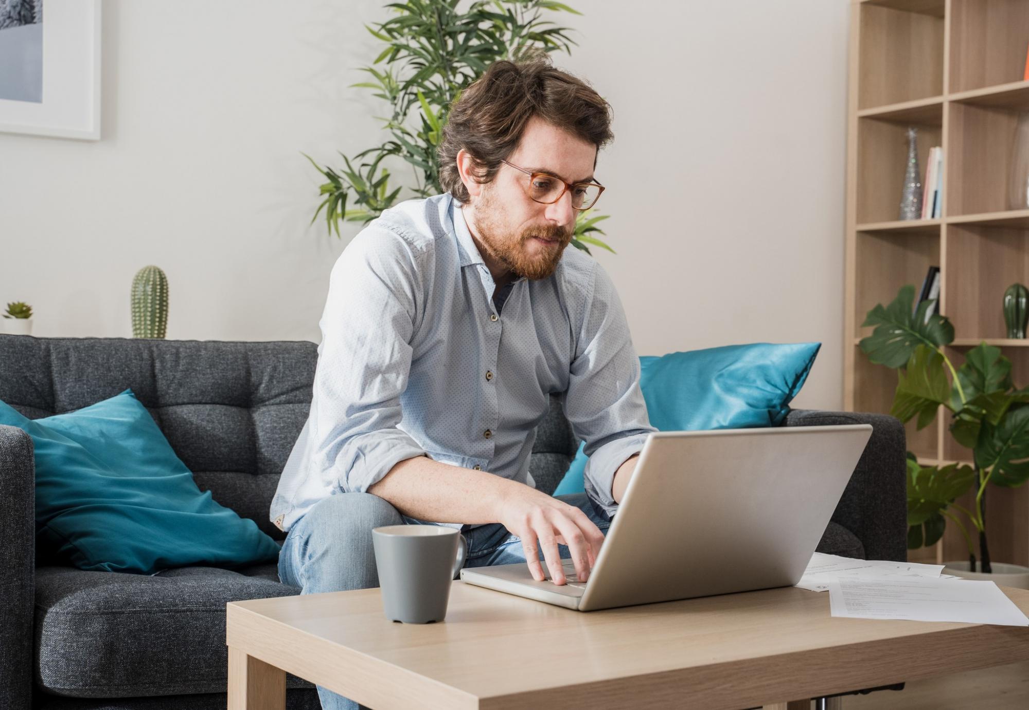 Man sits at computer, working from home.