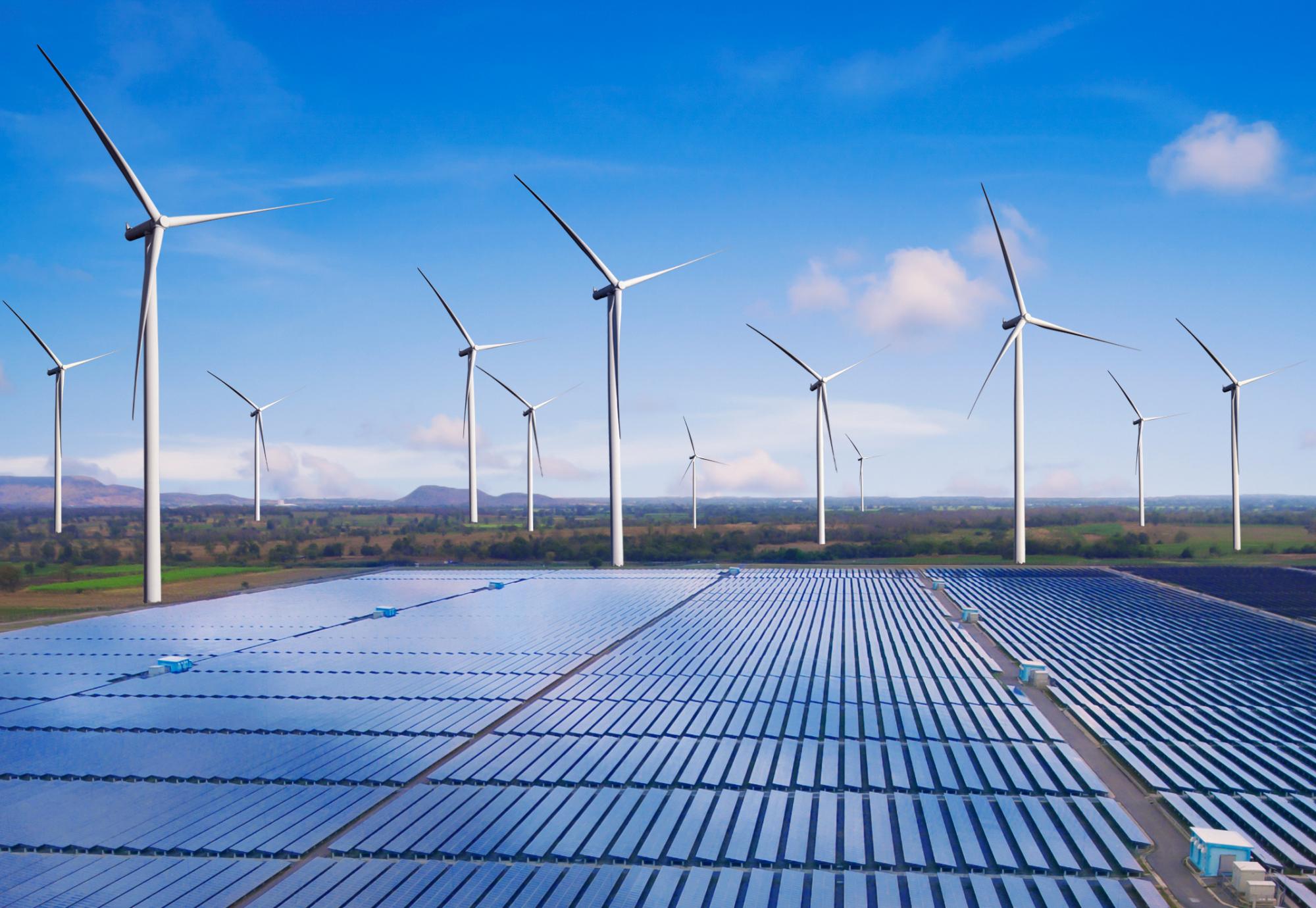 A field with wind turbine and solar panels.