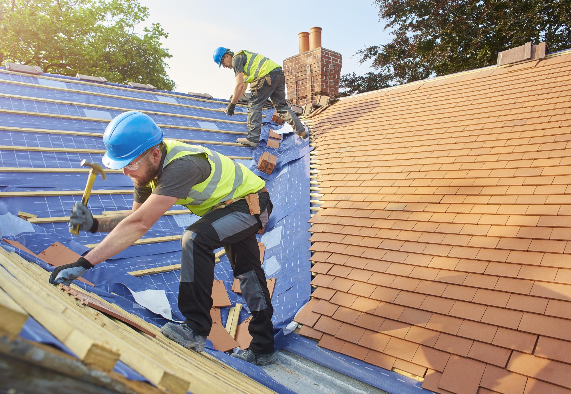 Builders tiling a roof