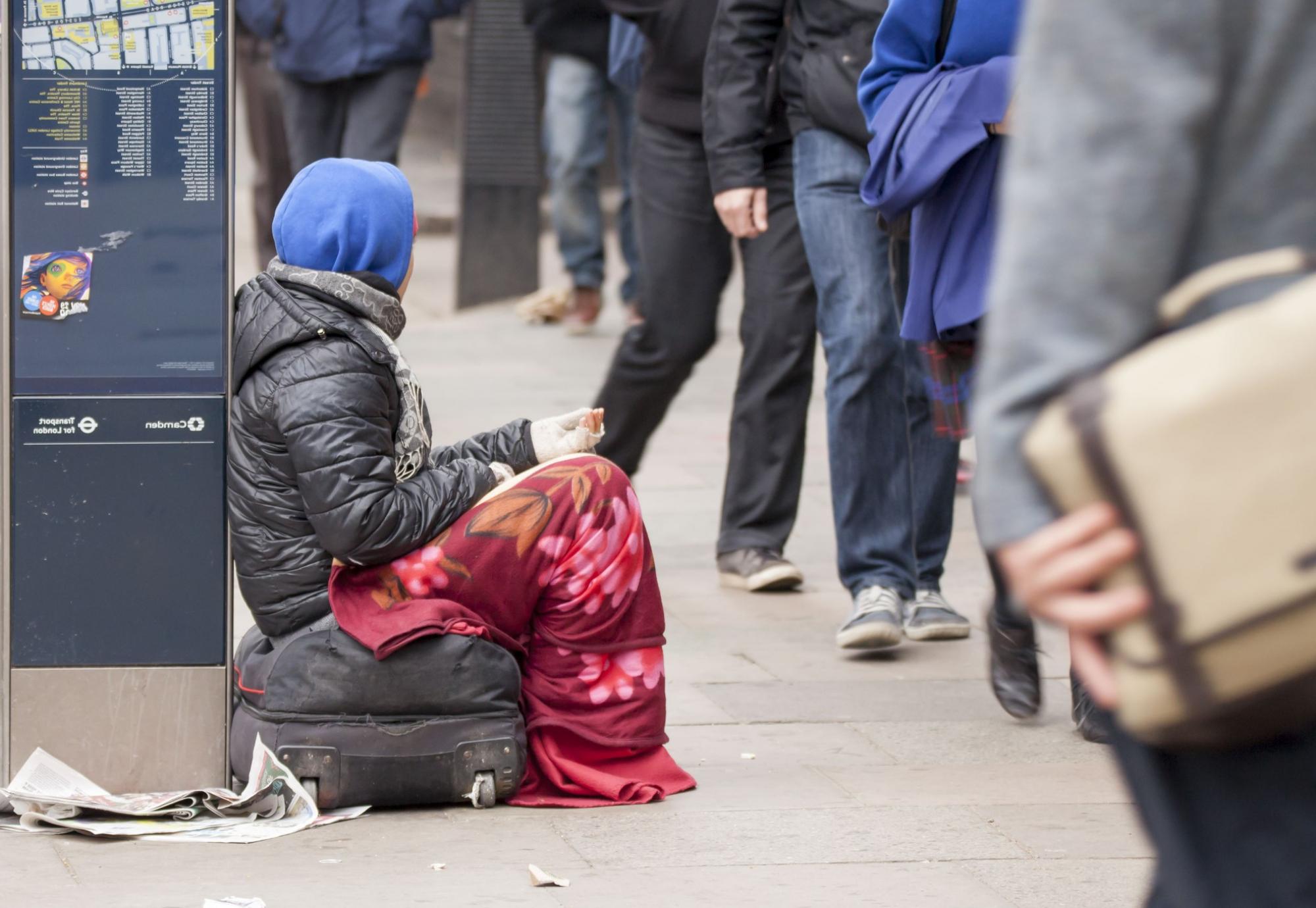 Homeless person asks passersby for money