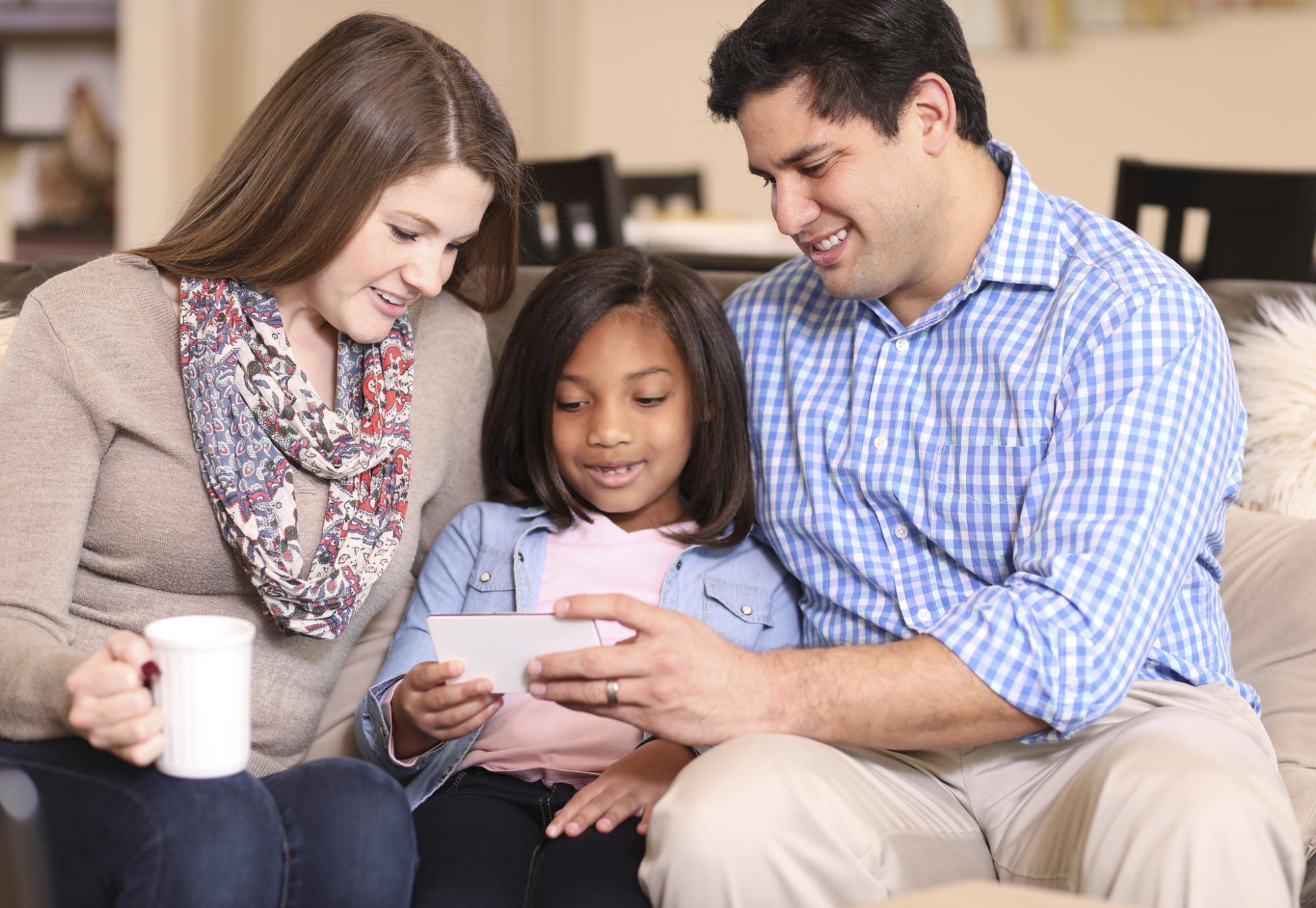 Adopted child sits with parents who are of a different race.