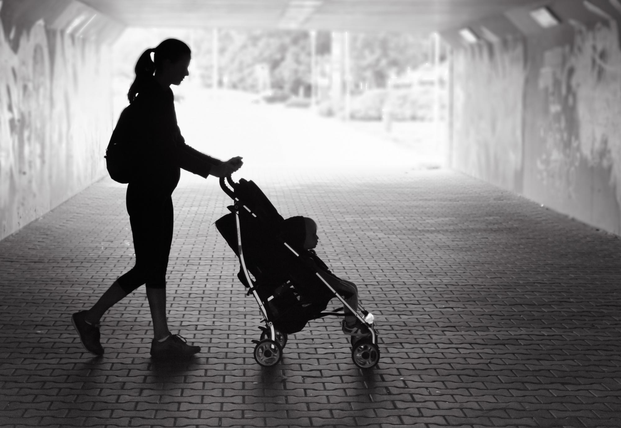 Black and white picture of single mum with pram.
