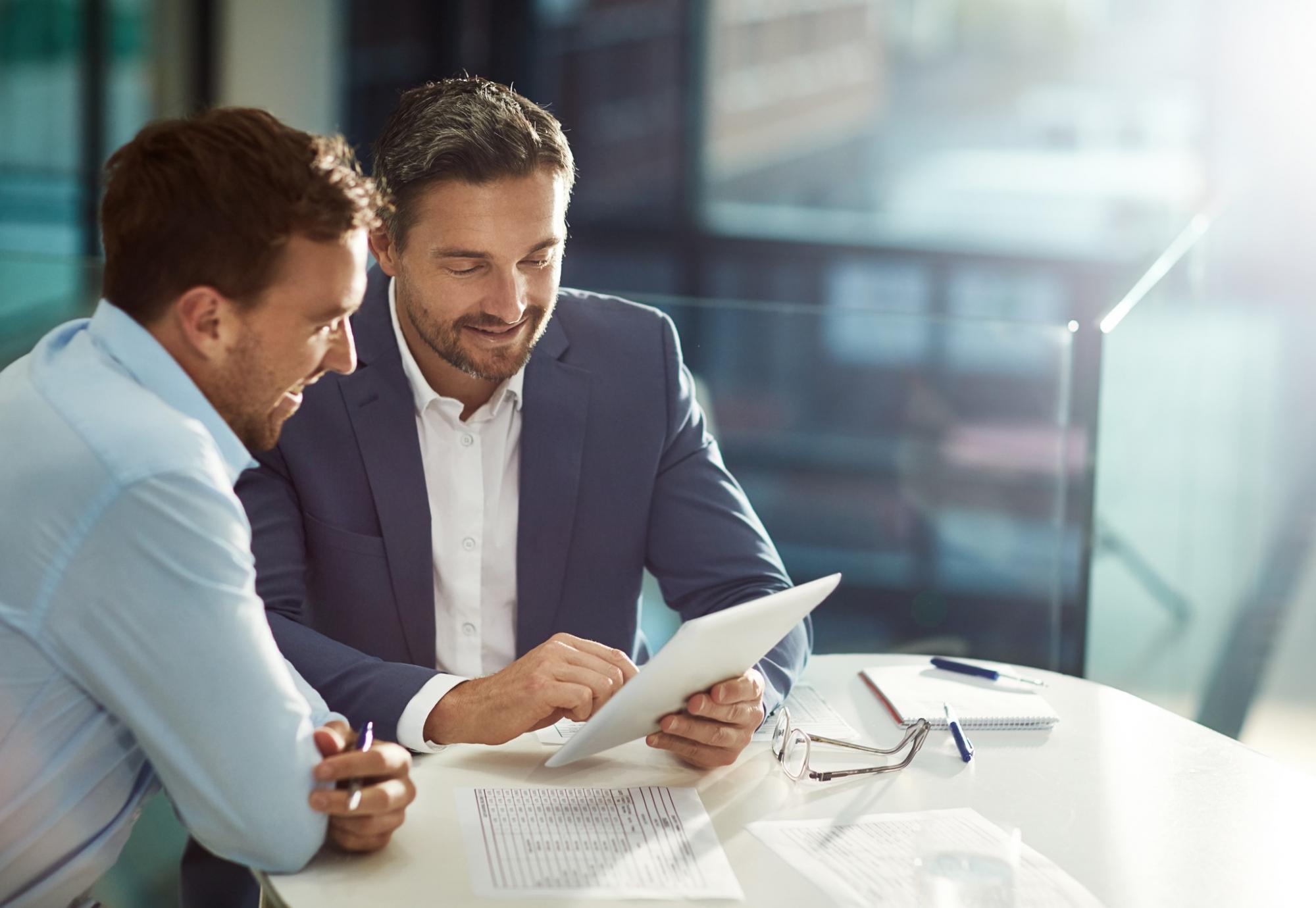 Two businessmen in discussions over a document