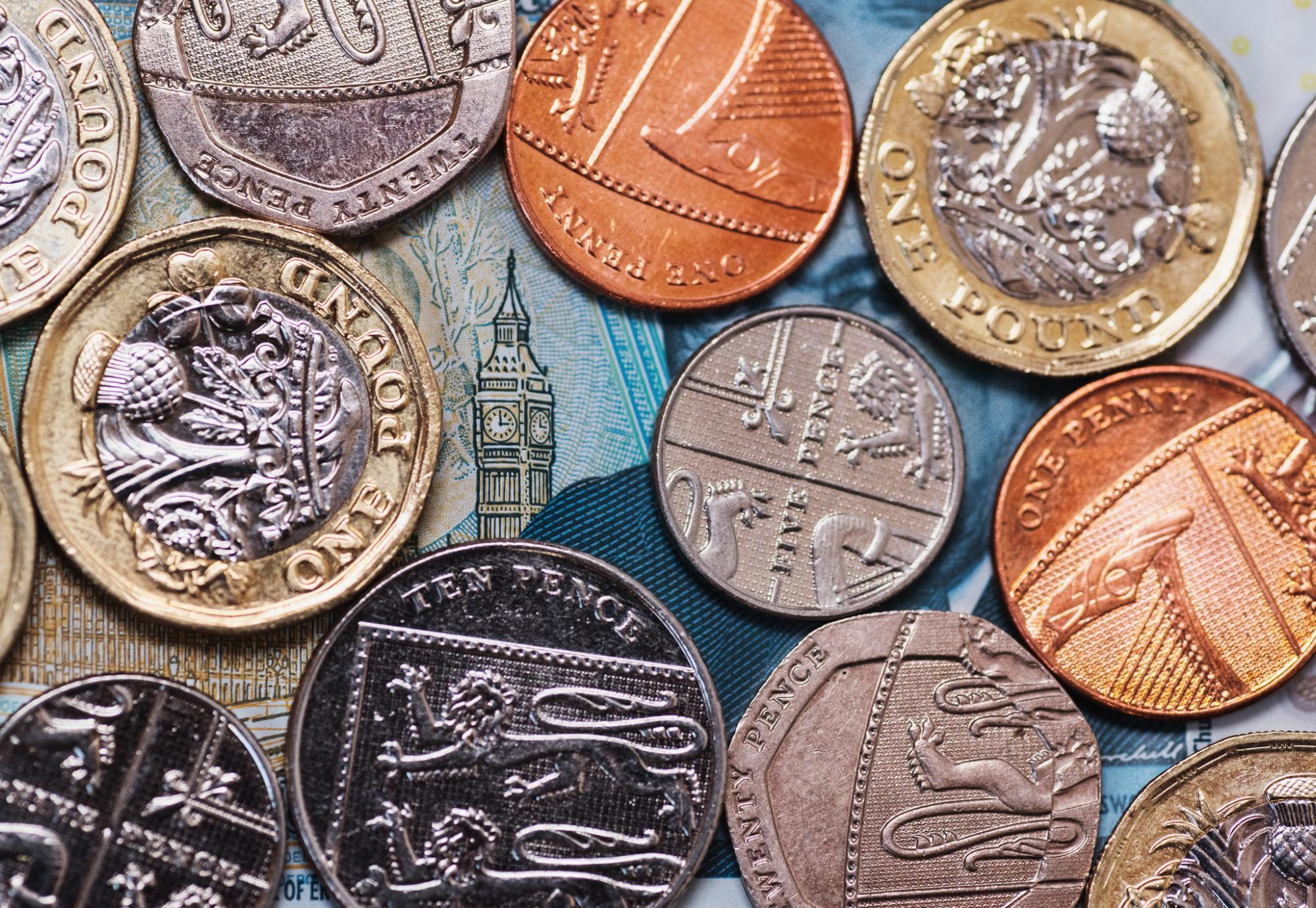 Coins placed over a five pound note revealing the Elizabeth Tower.