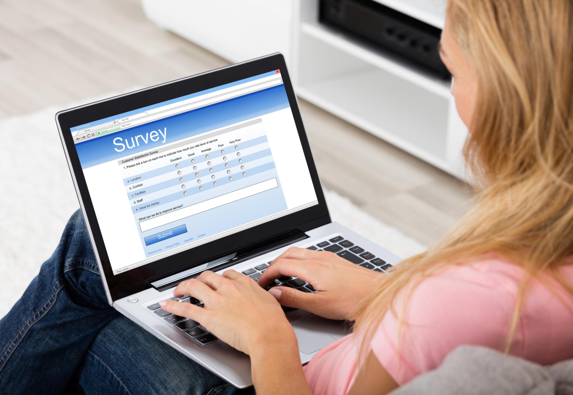 Woman fills in online survey on her laptop. 