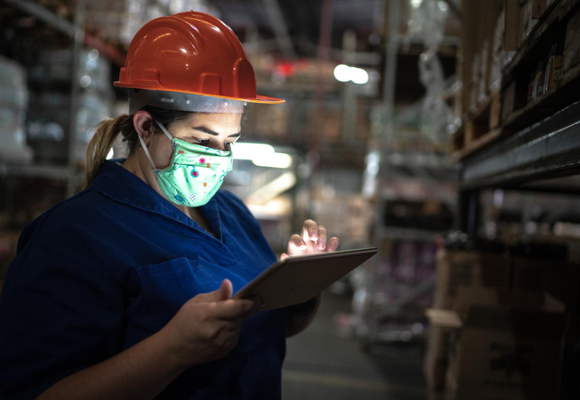 Girl in warehouse working on a tablet.