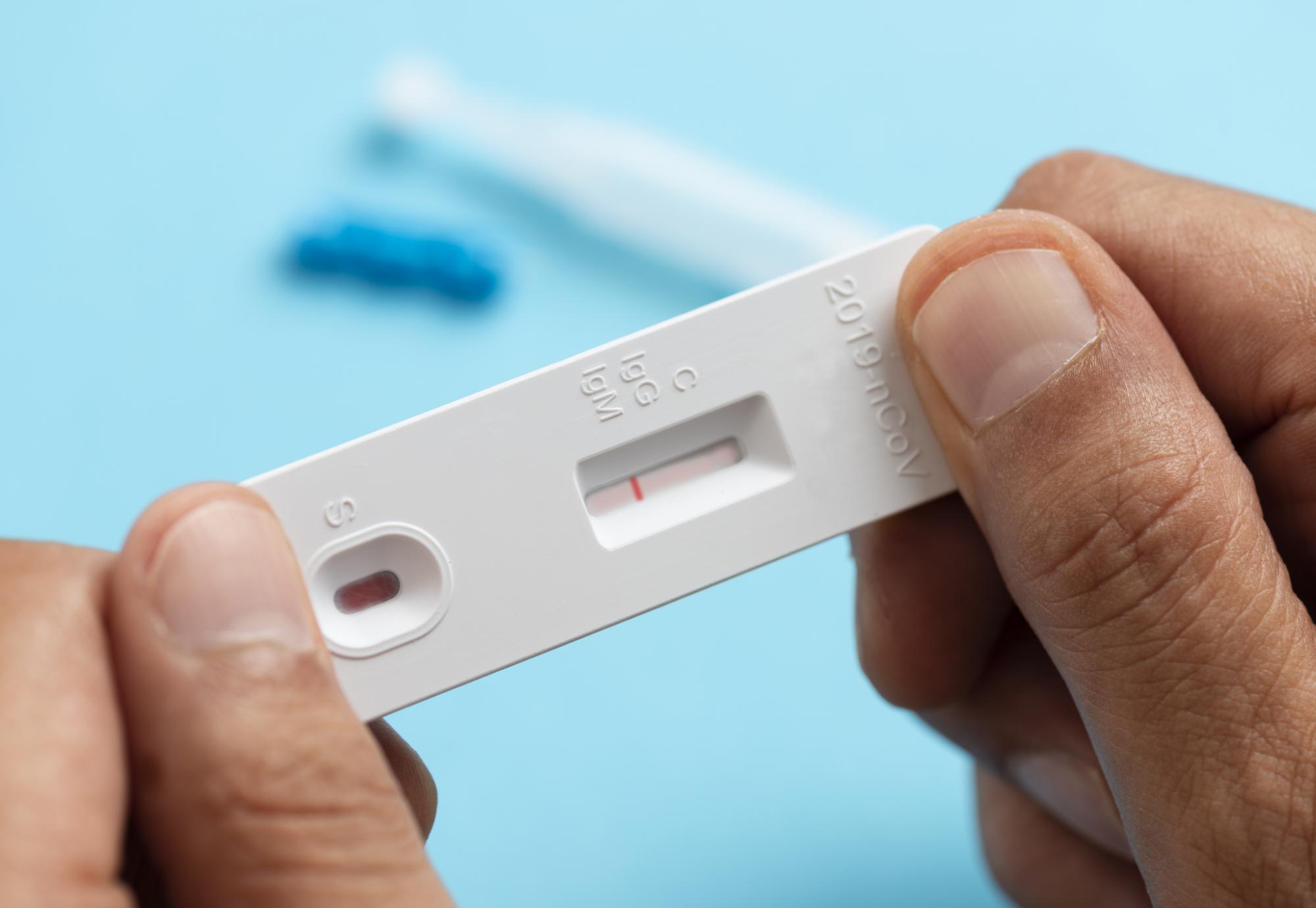 Man looks at lateral flow covid test