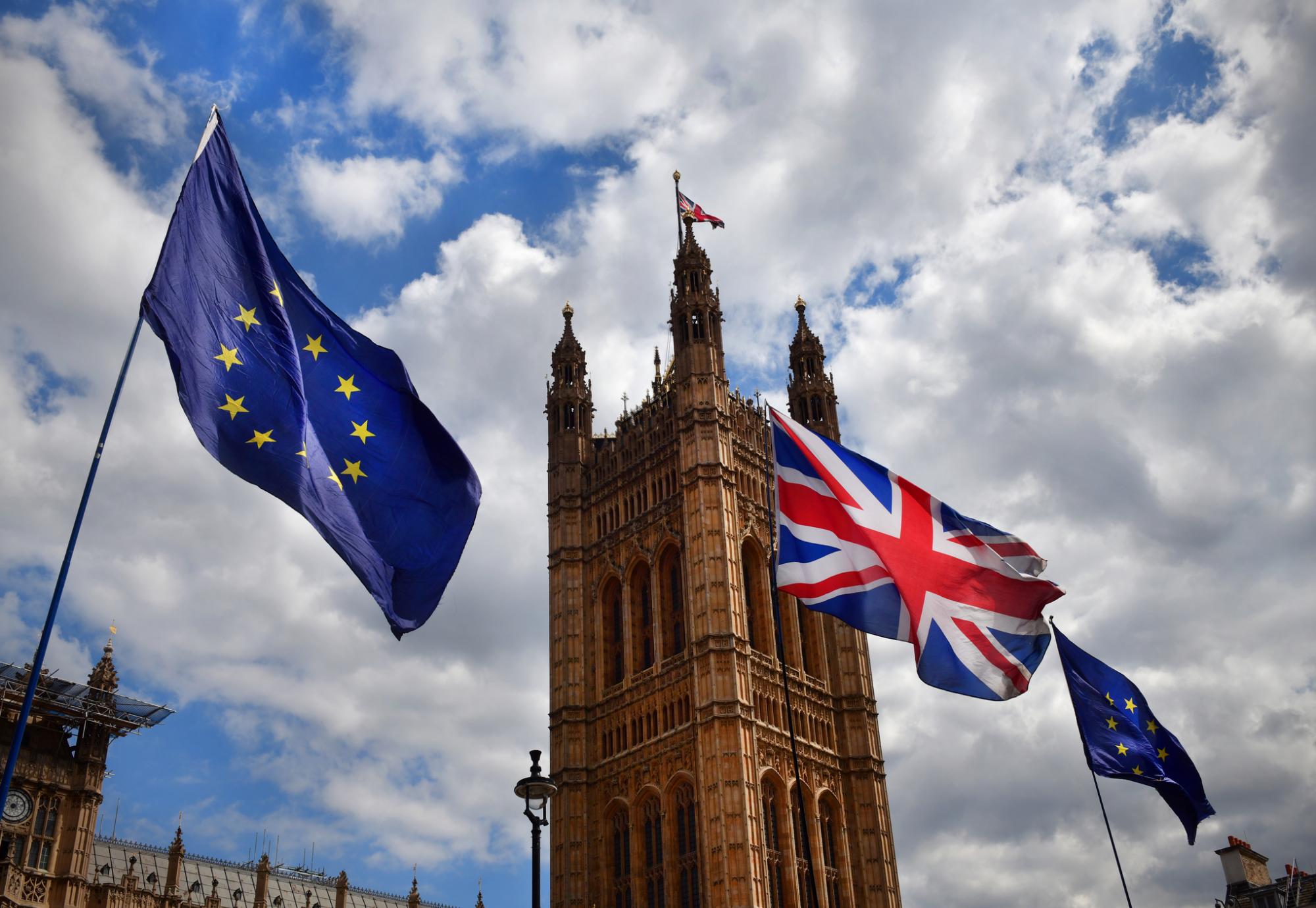 EU and Union Flag fly next to Parliament.