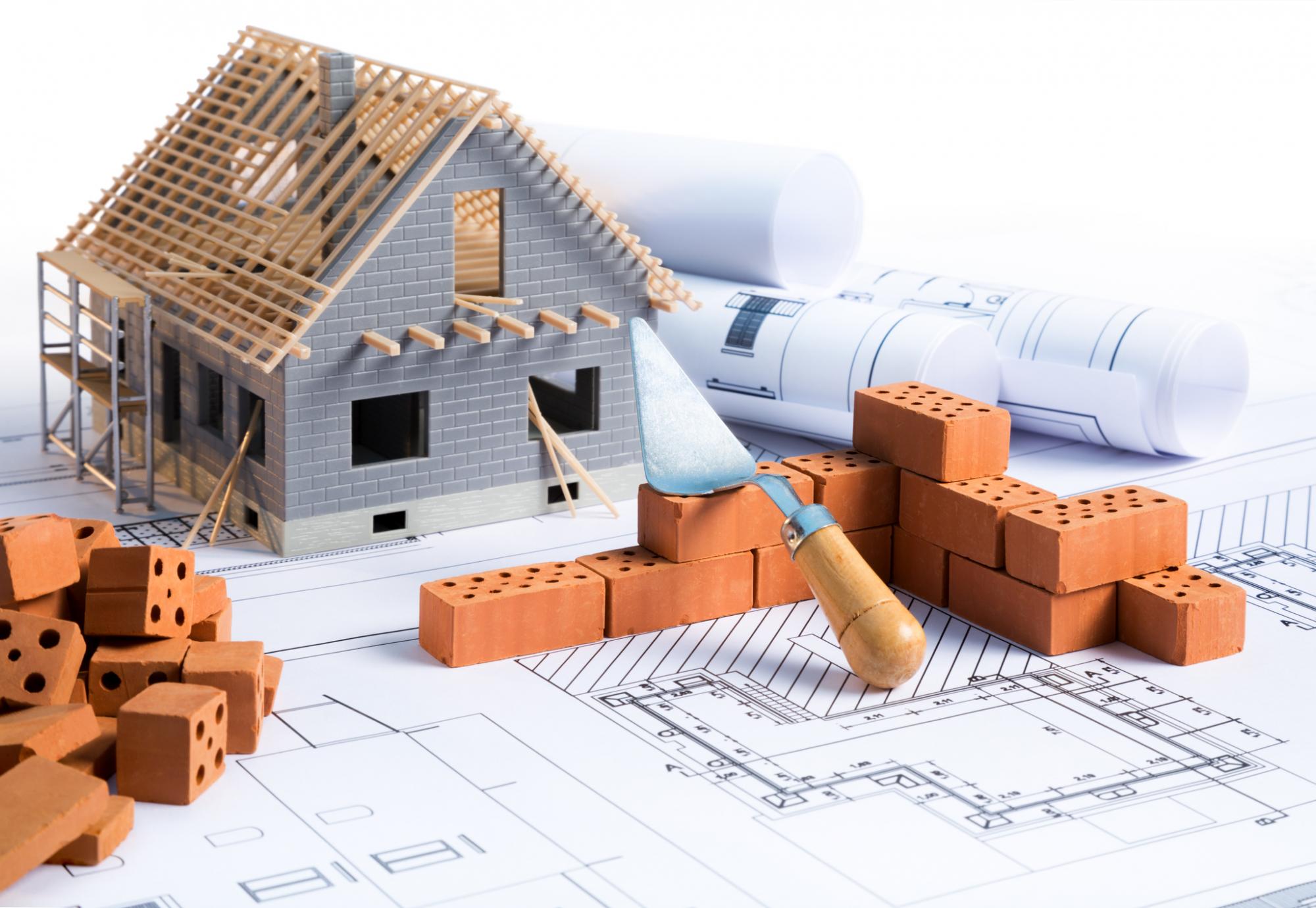 Small house being built with miniature bricks. 