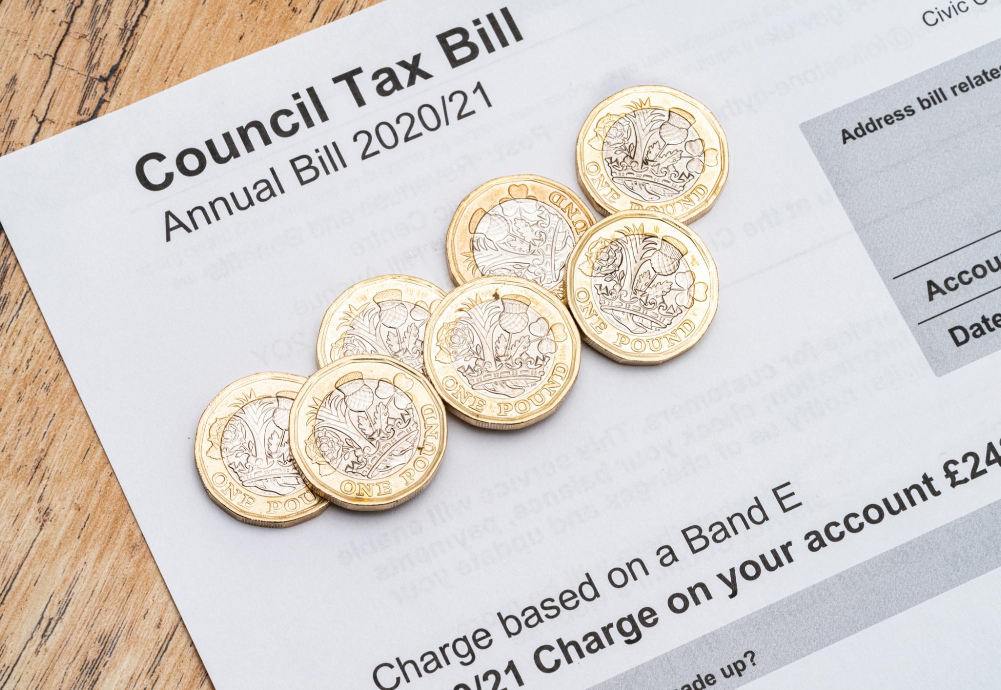 Council tax bill with coins on top.