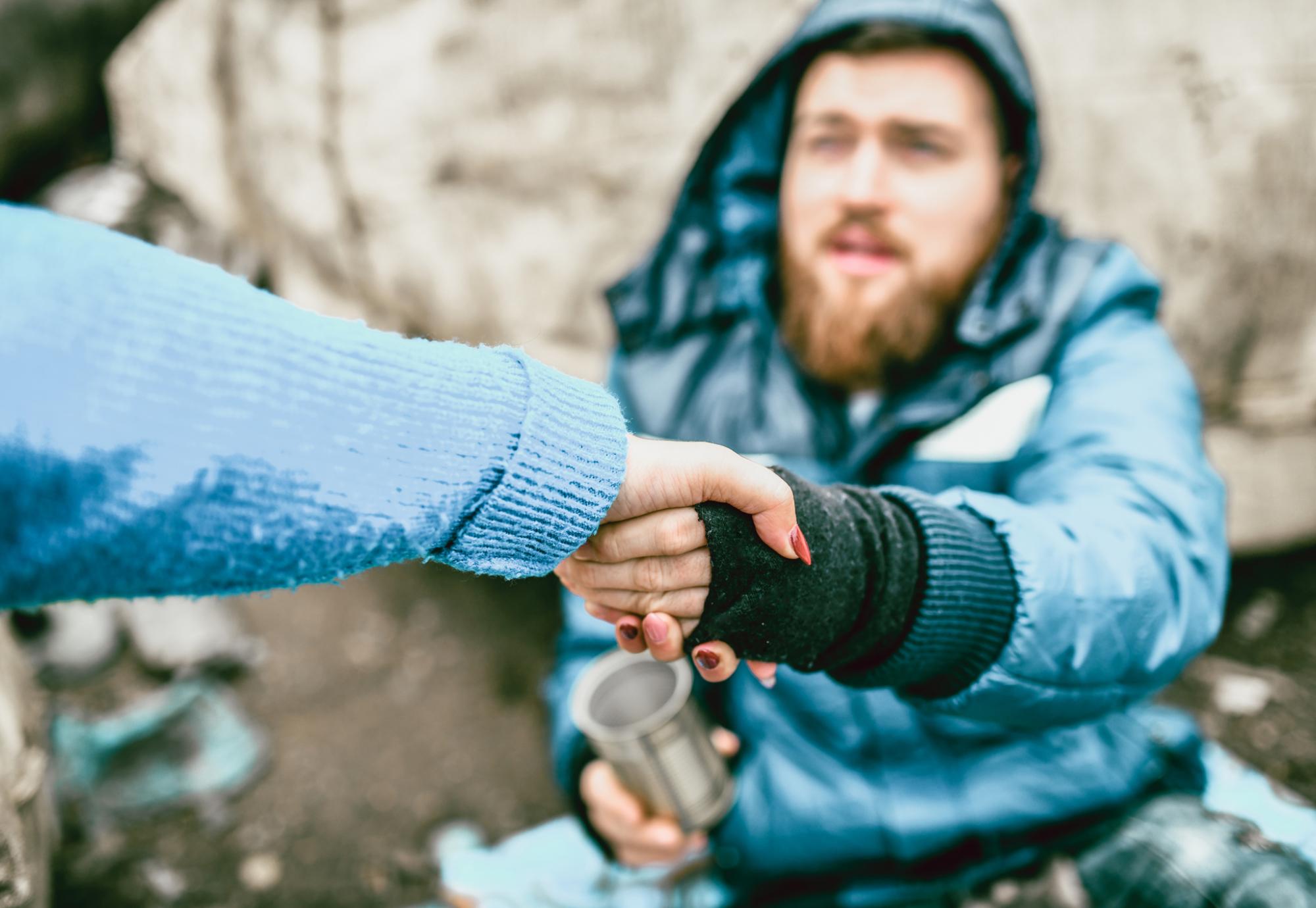 Homeless man is helped by passerby