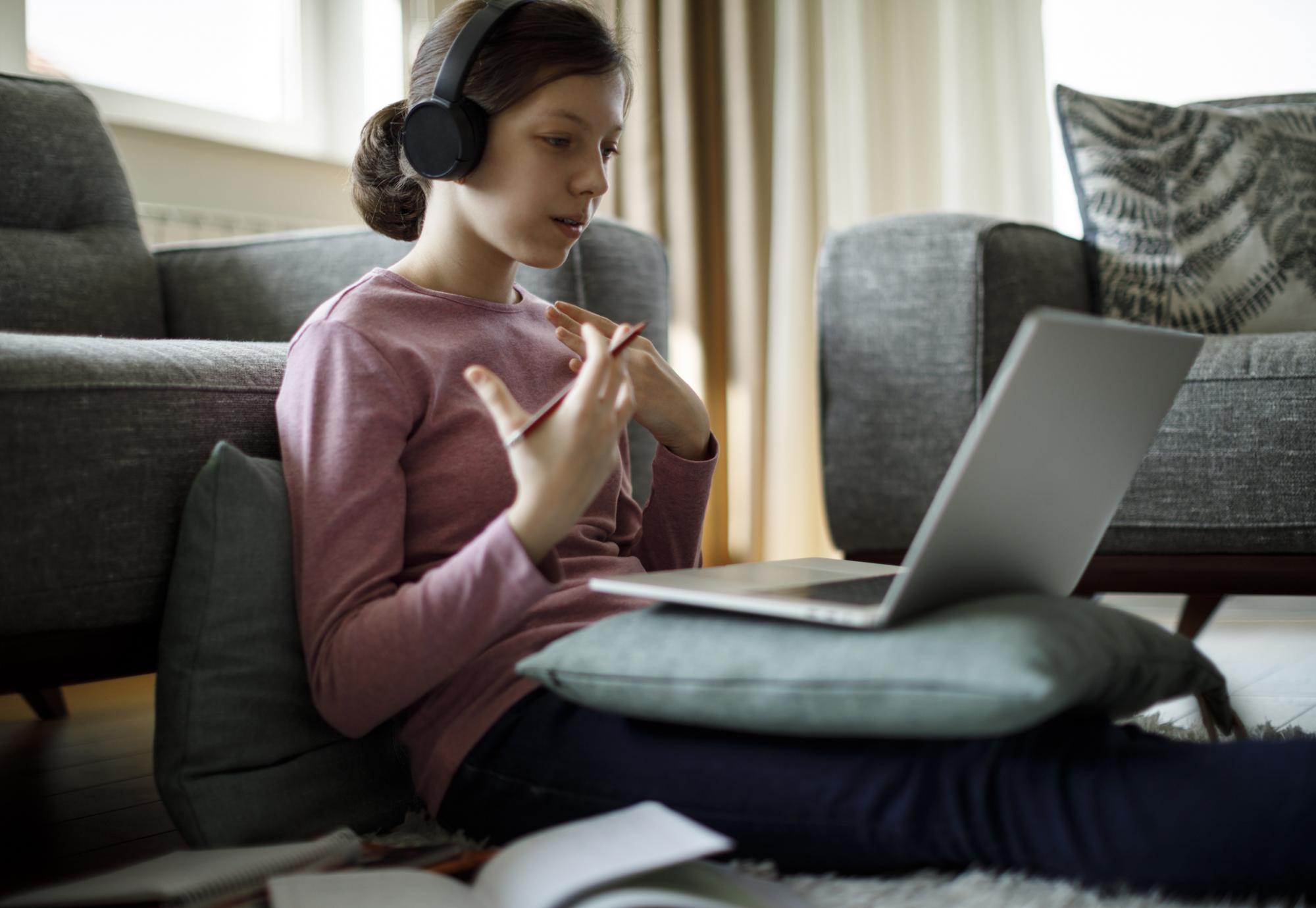 Girl sits in front of laptop remote learning