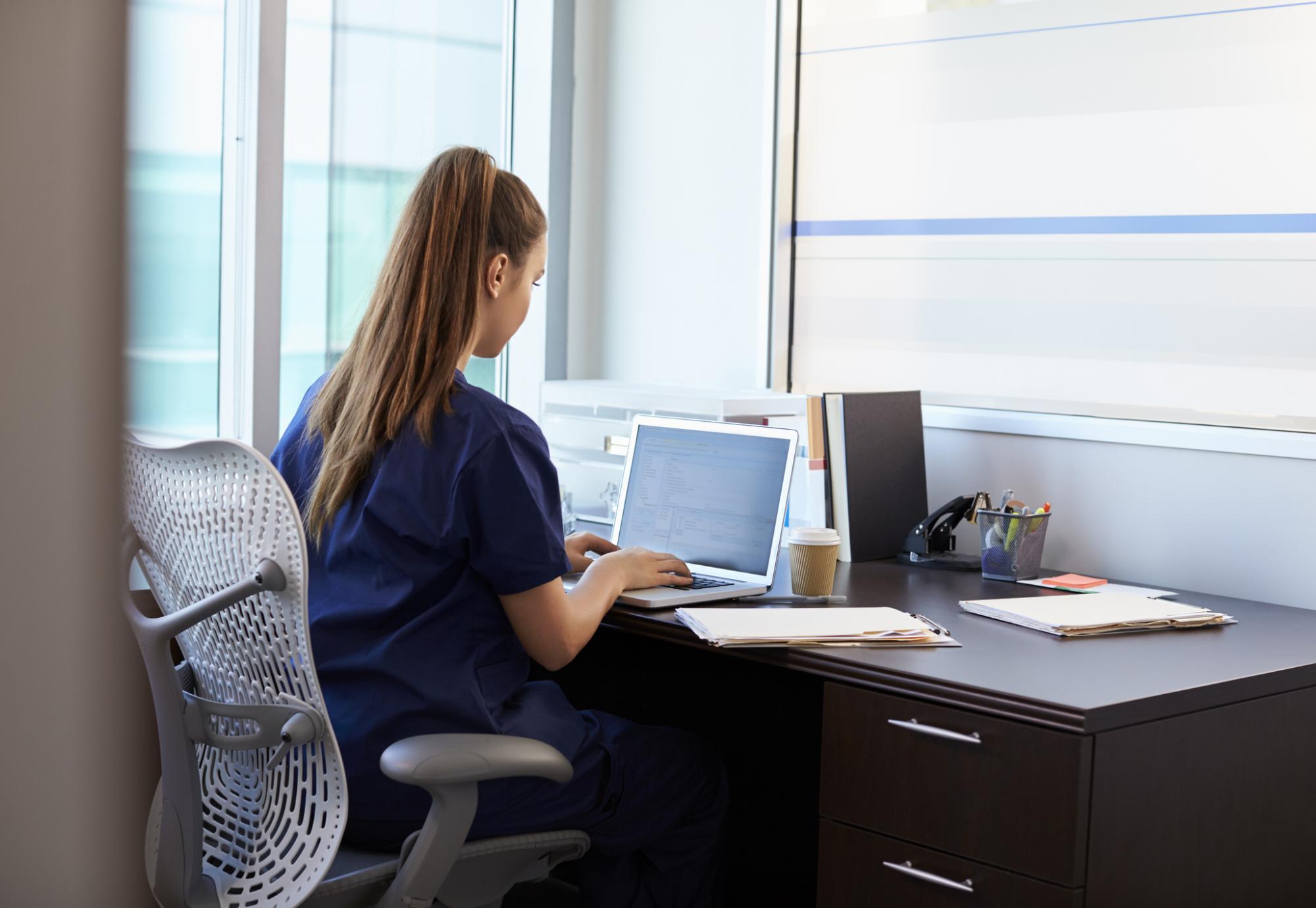 Student nurse sits at desk. 