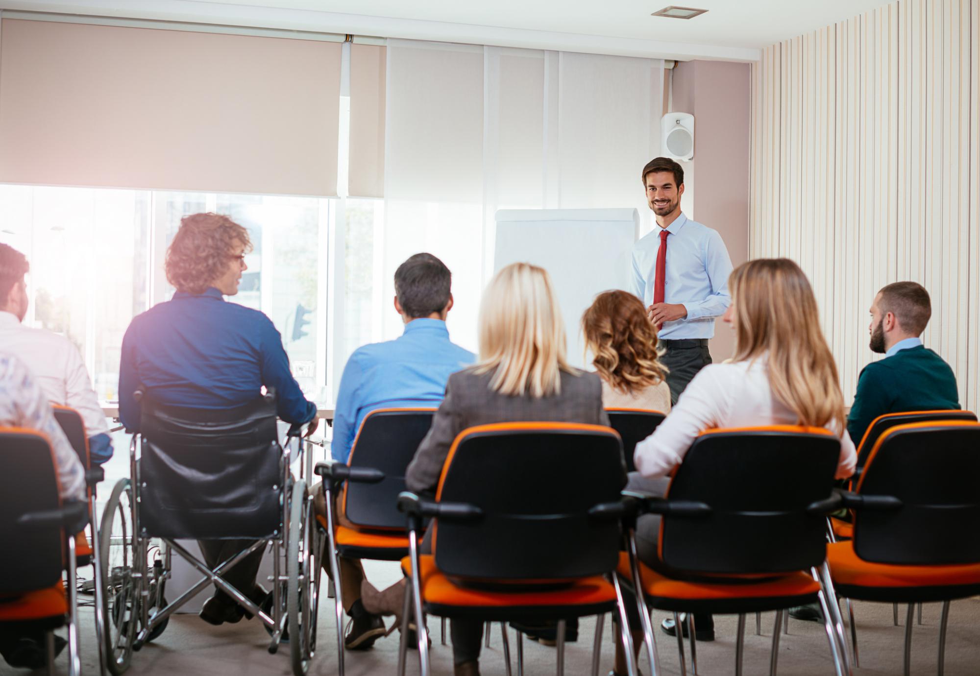 Man addresses a group of conference delegates