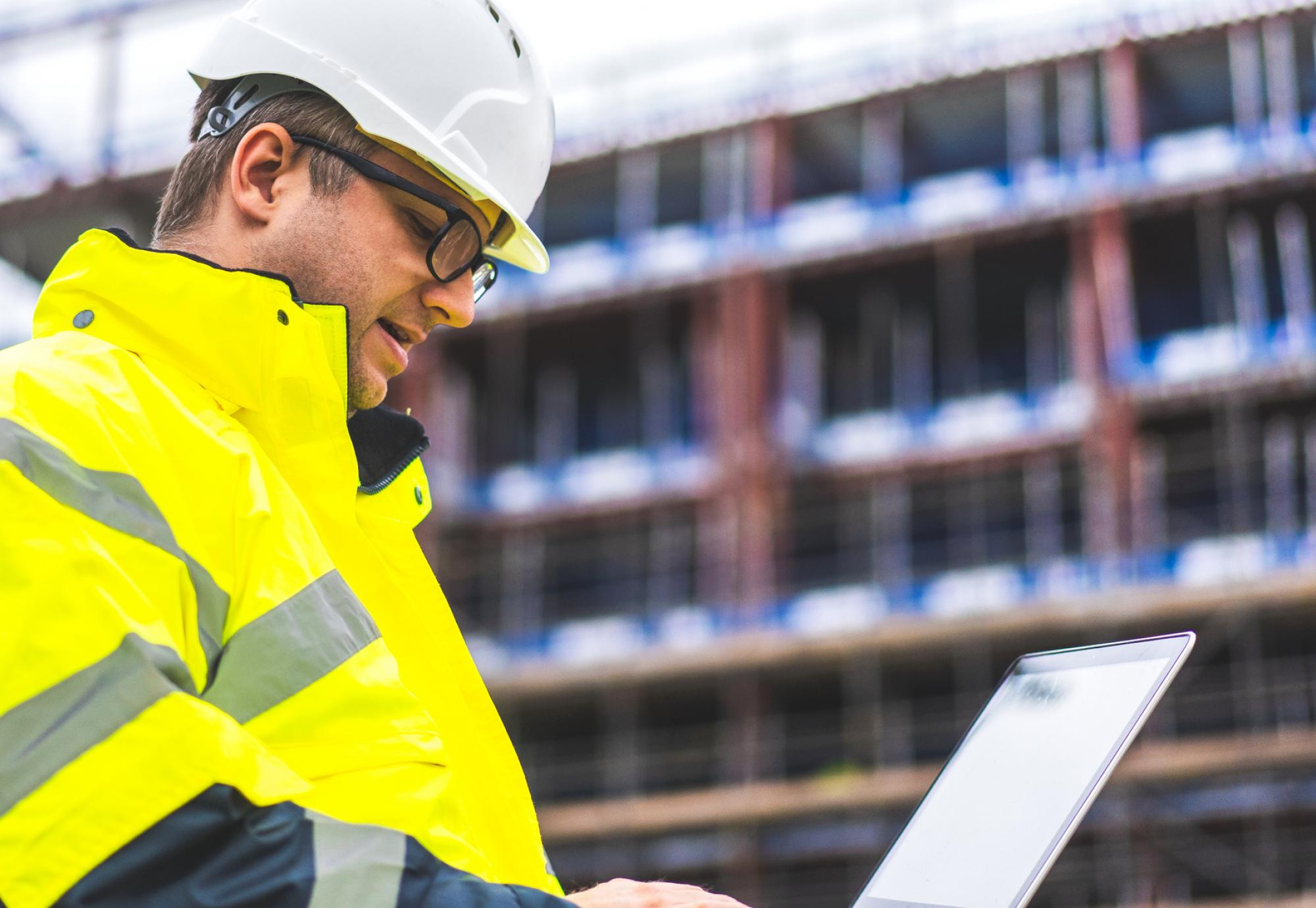 Engineer on building site with laptop