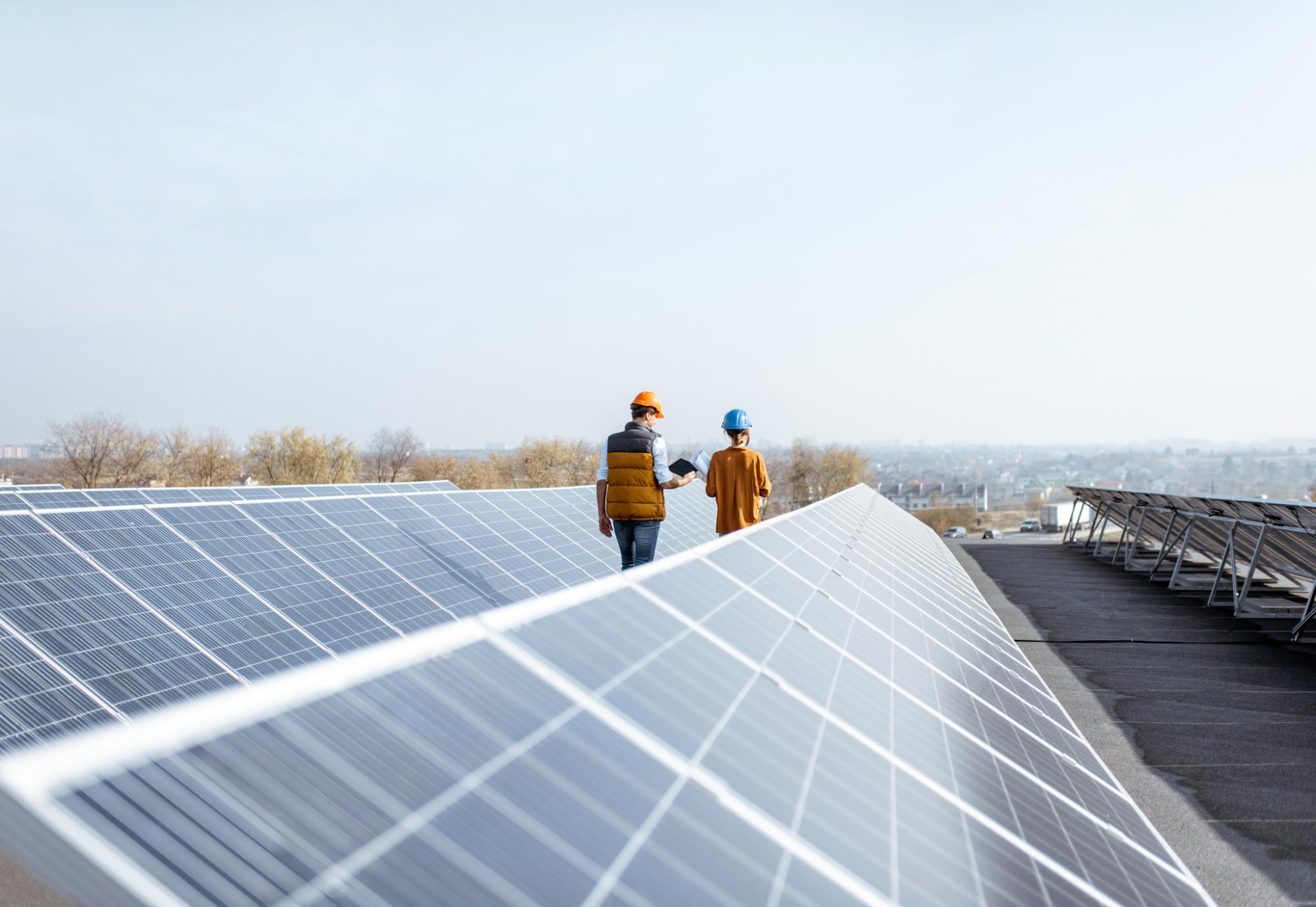 Workers on a roof with solar panels