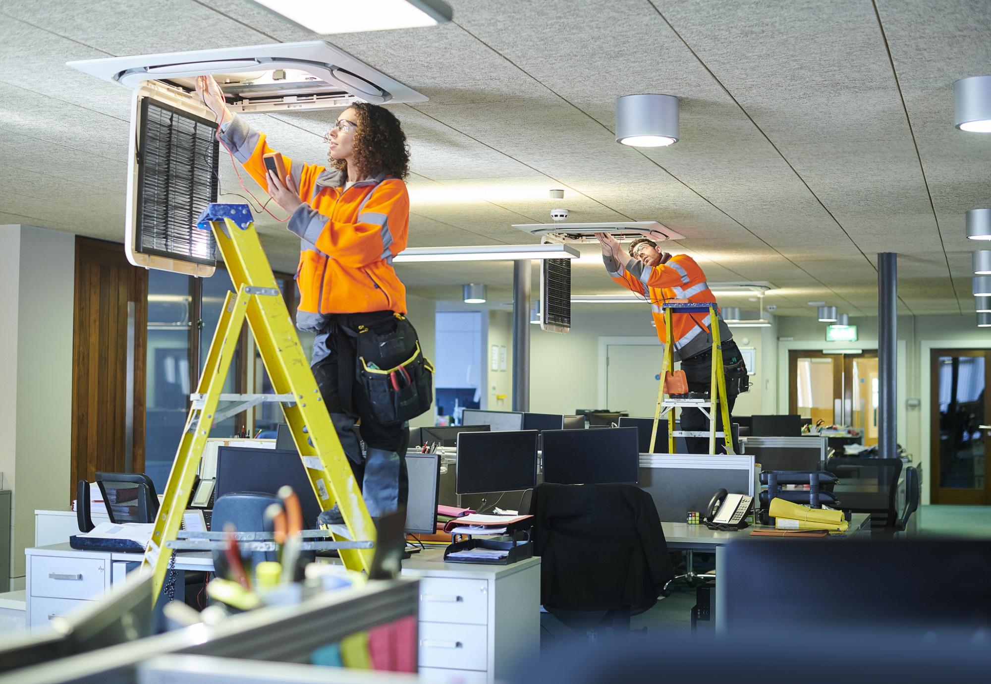 Technicians changing lights in an office building
