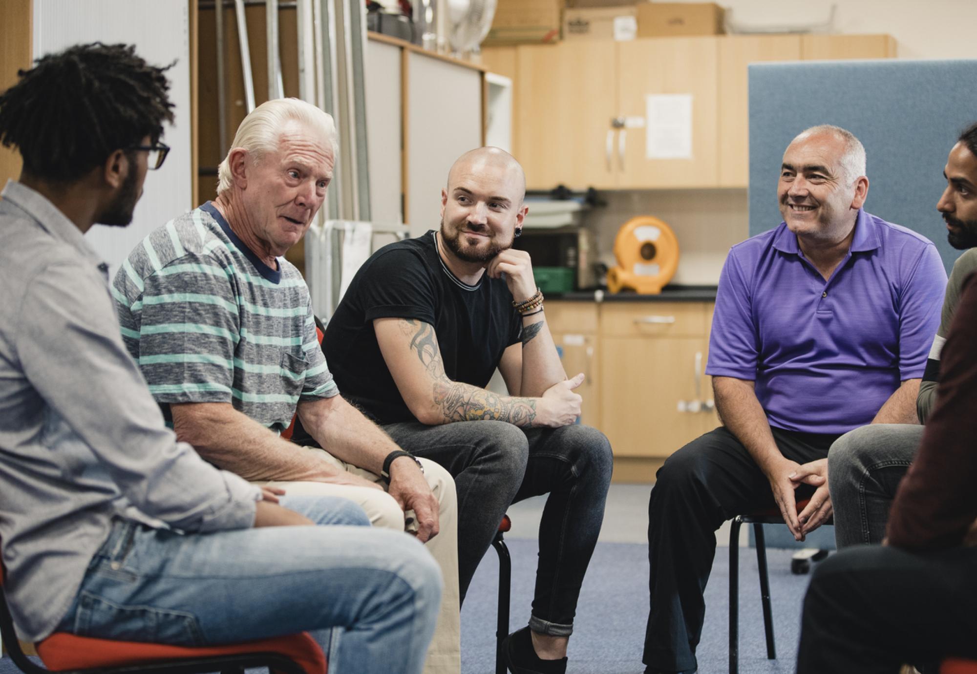 Group of men in community support meeting