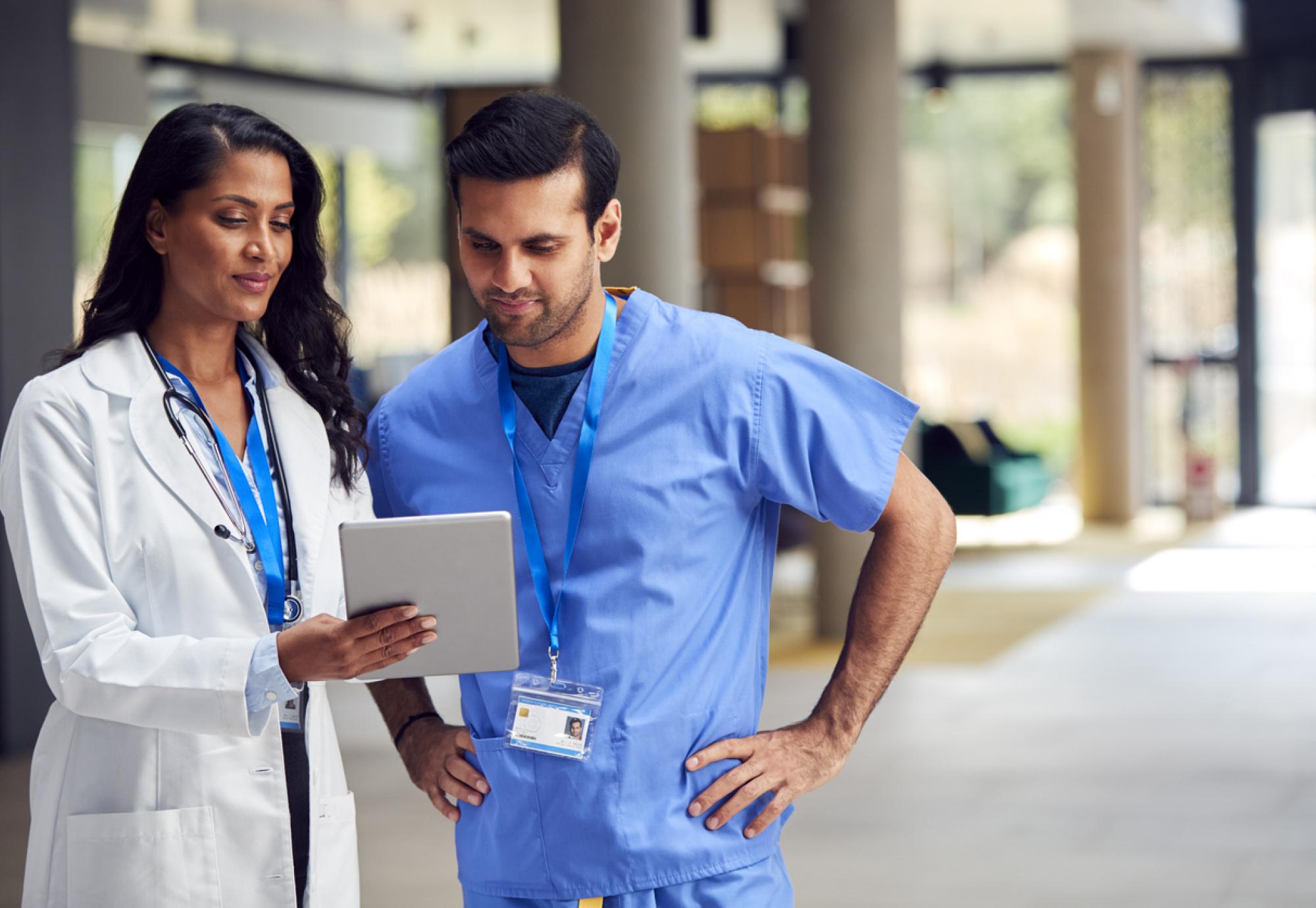 Two healthcare professionals looking at a tablet PC