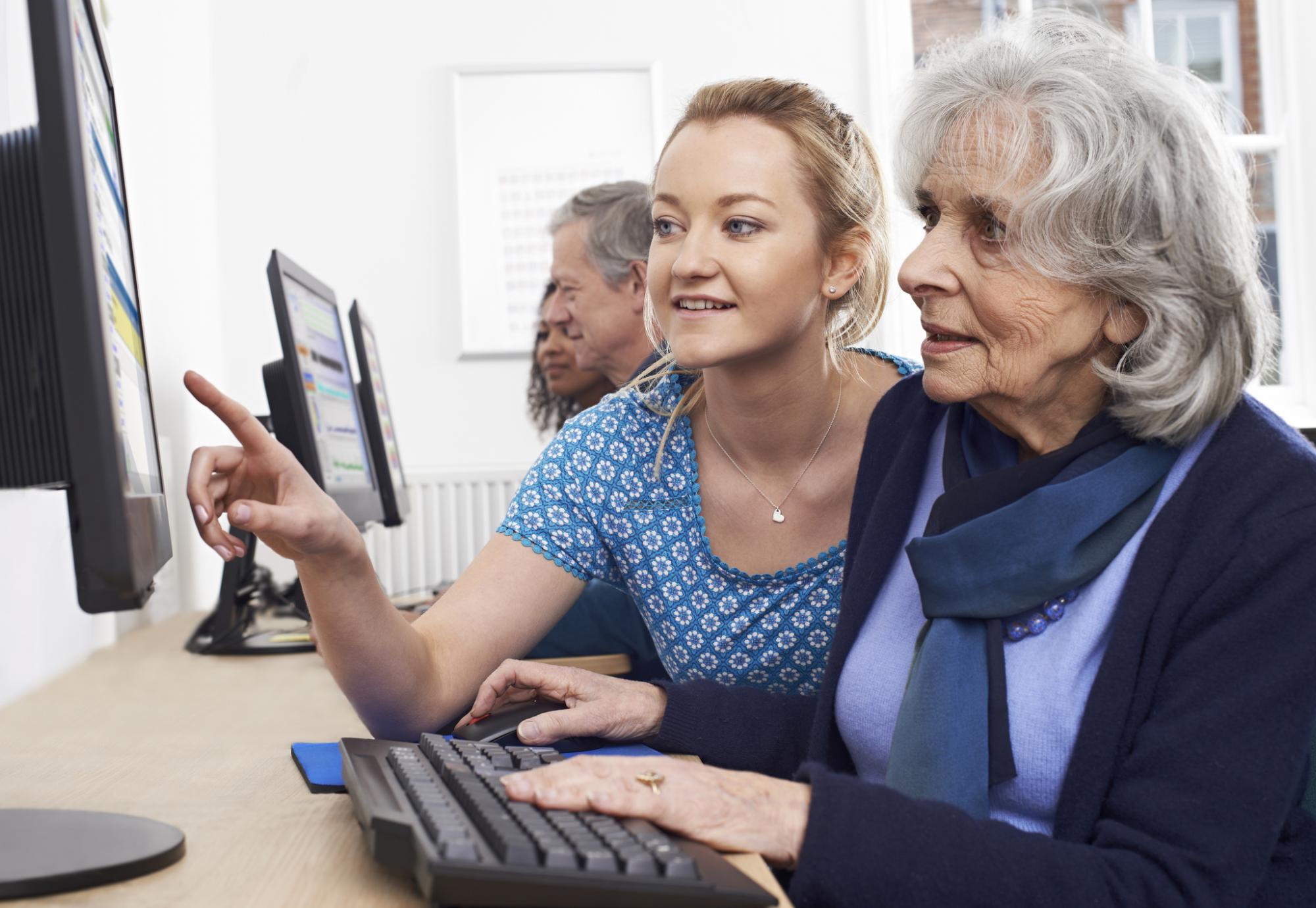 Elderly resident being taught to use a computer