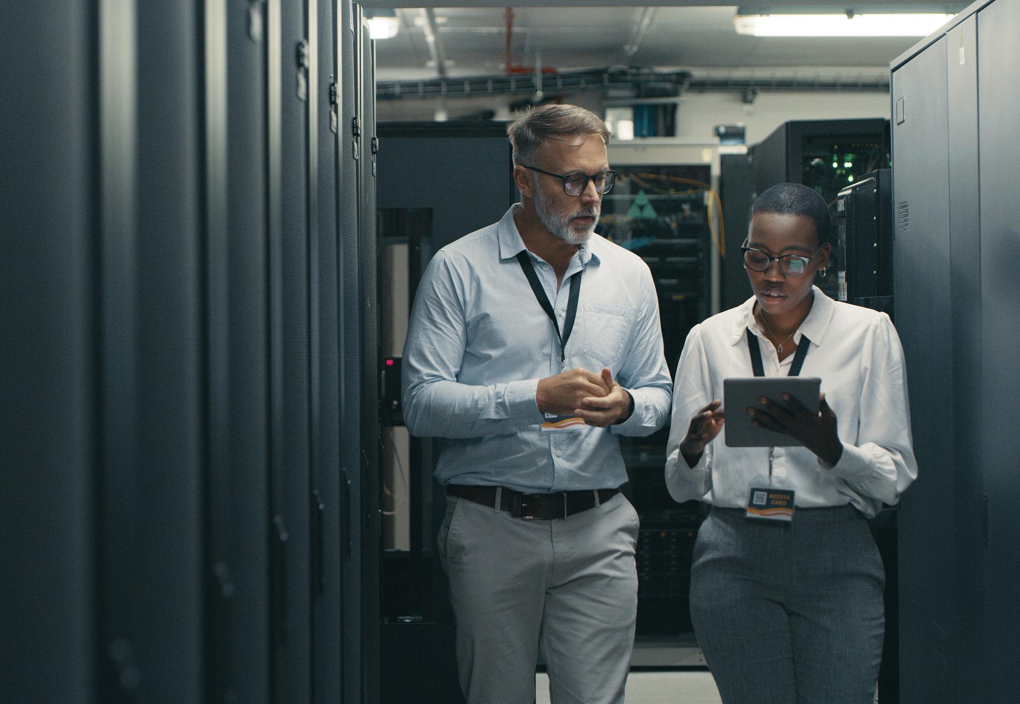 Two people walking through IT infrastructure