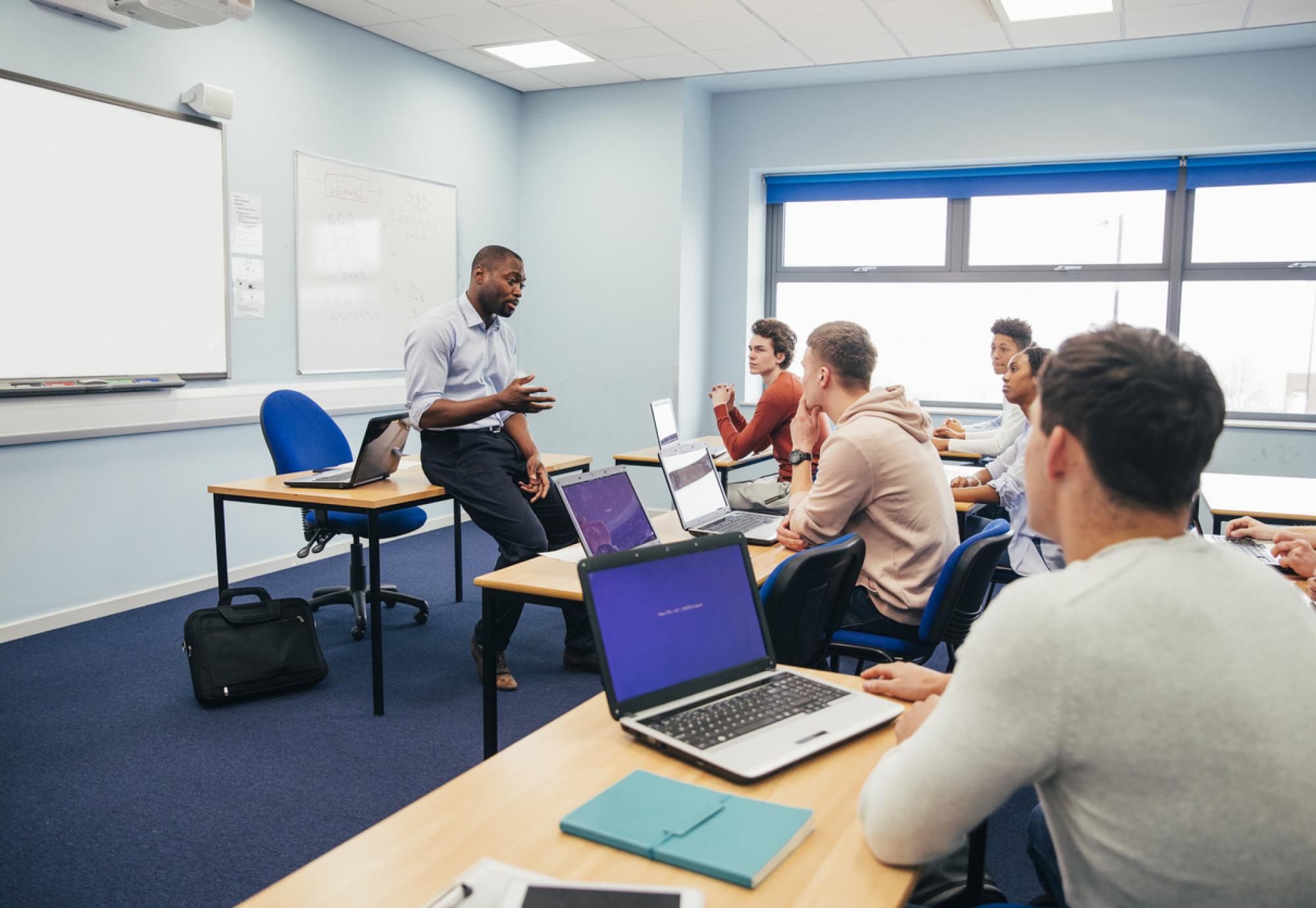 A male teaches a class of further education students