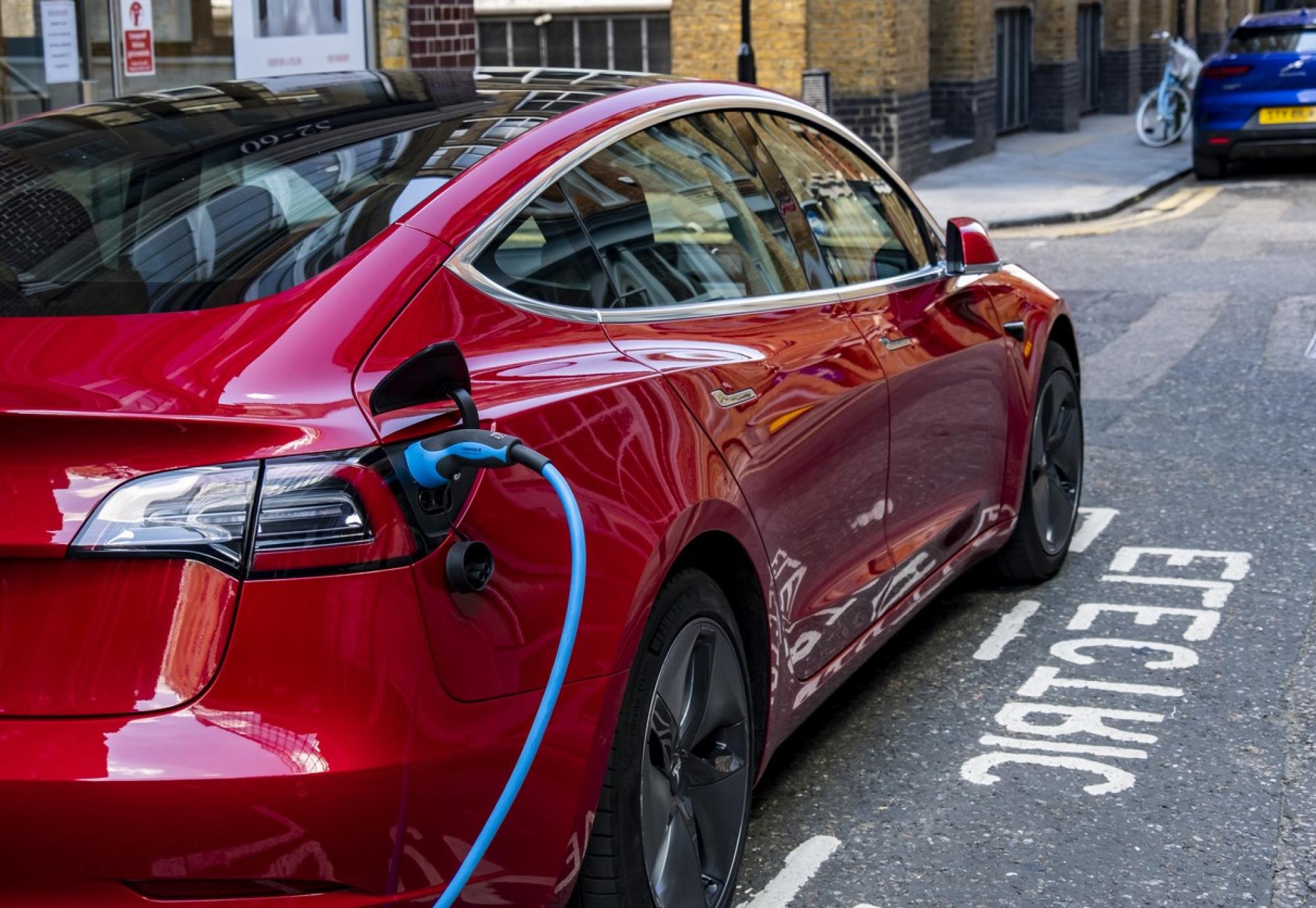 An electric vehicle charging at the side of the road