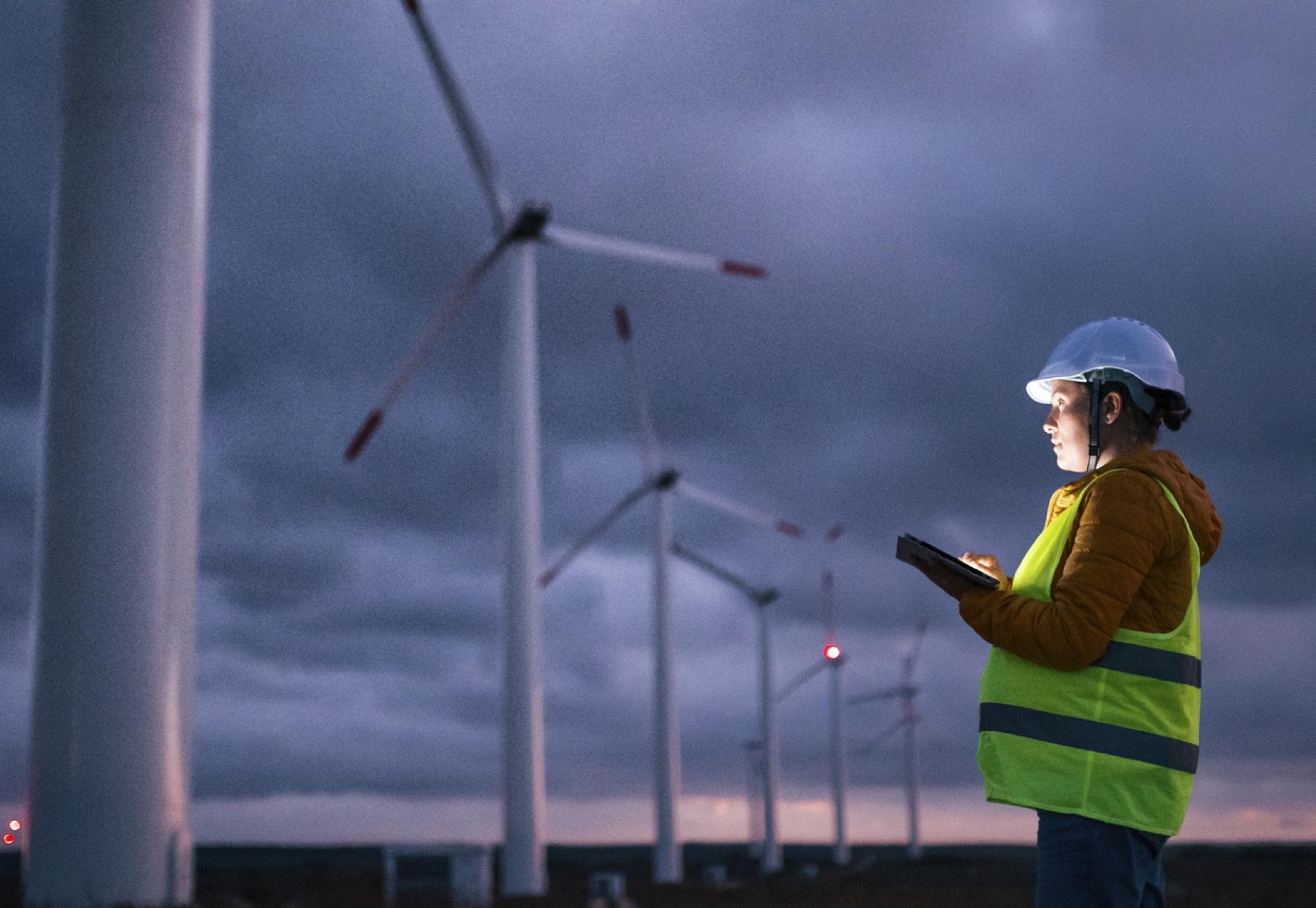 Woman observing wind turbines