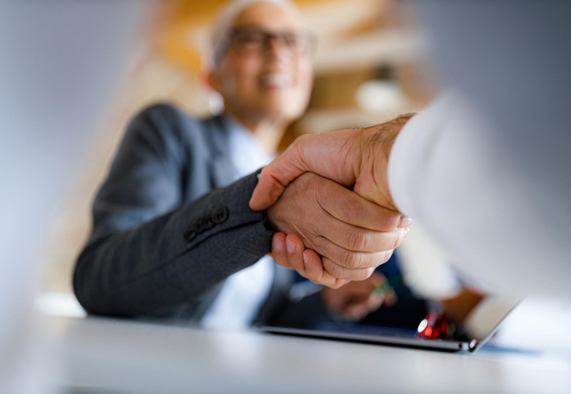Close up shot of two people shaking hands in a business environment