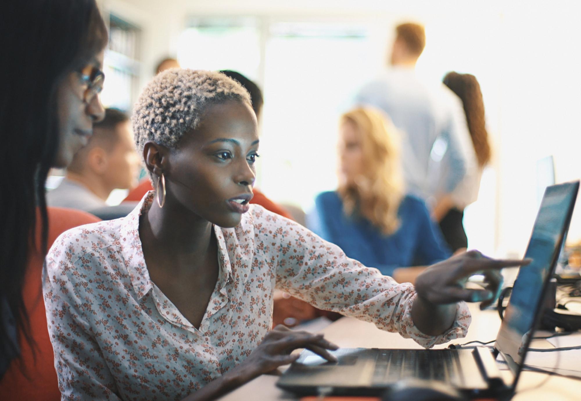 A woman points at a computer