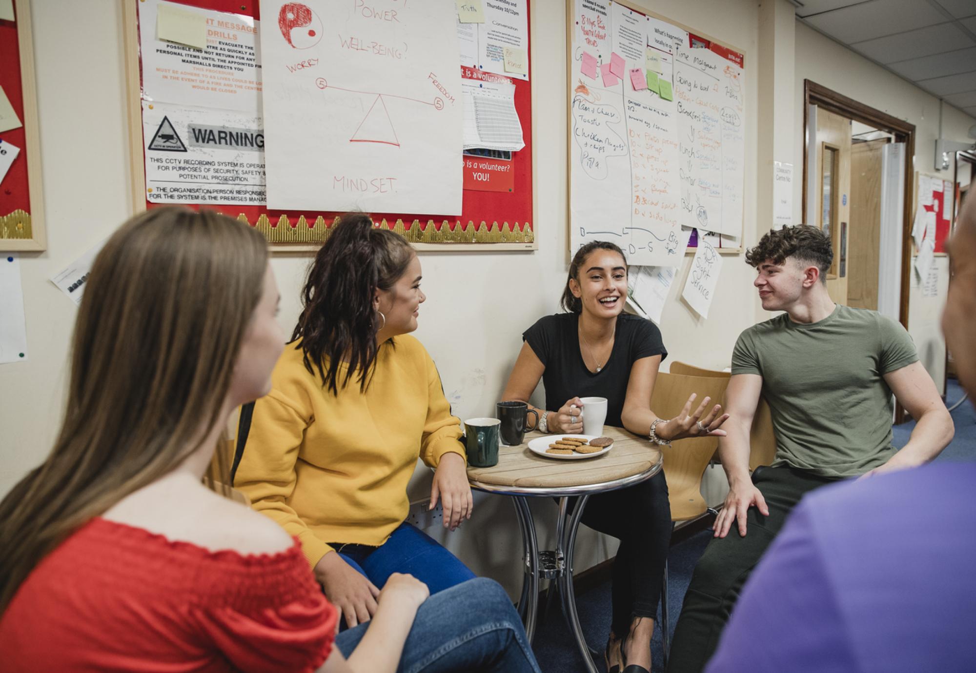 Group of young people sat together talking