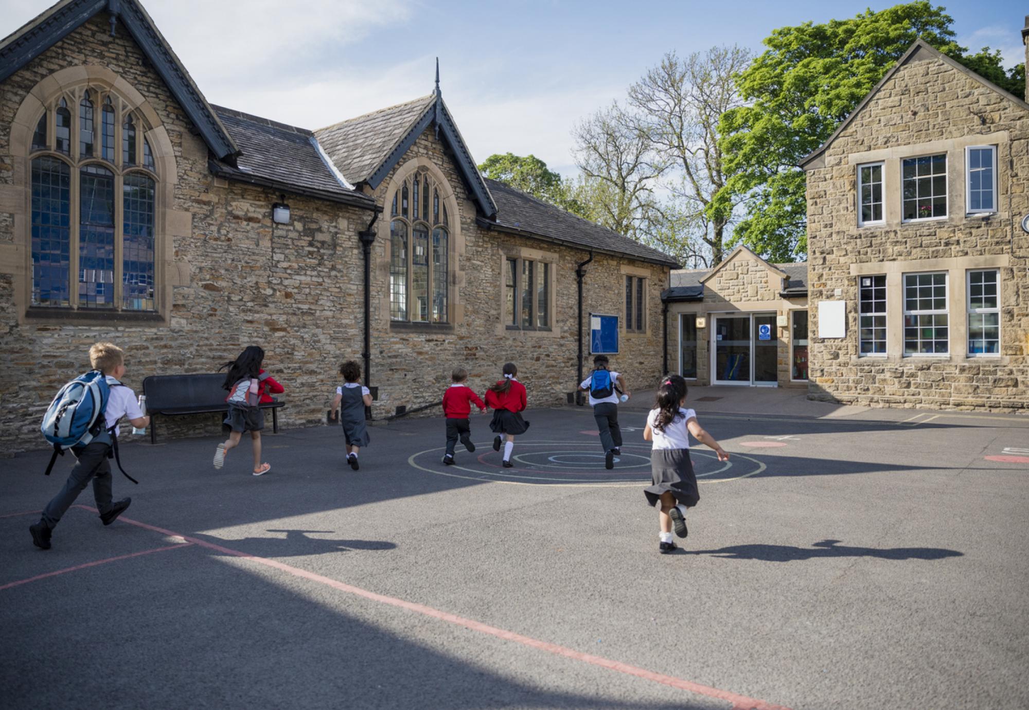 Children running through a playground of a primary school