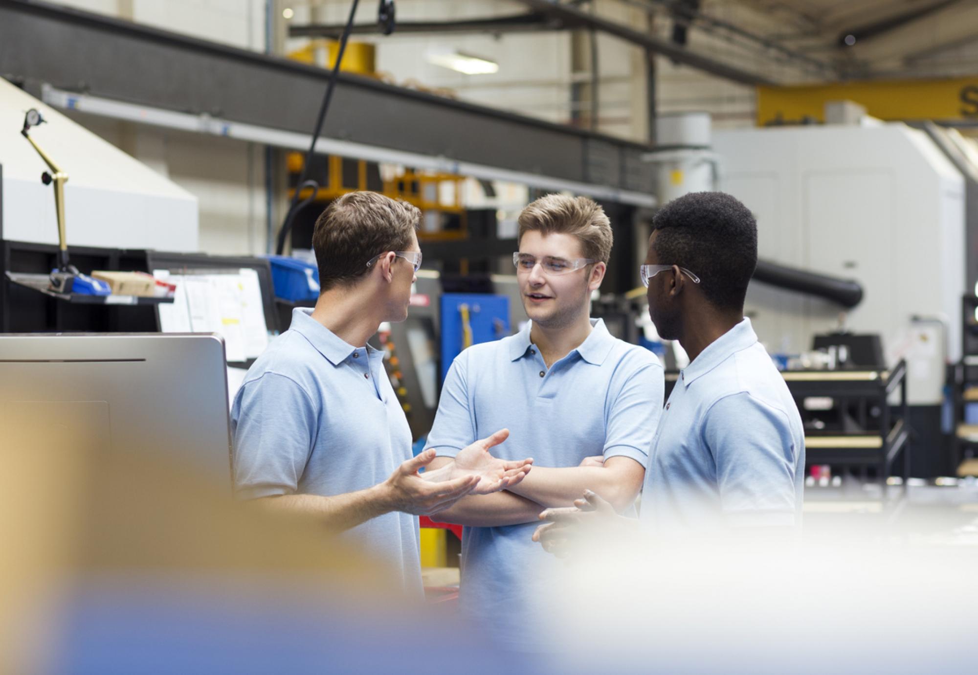 Three male apprentices discussing something