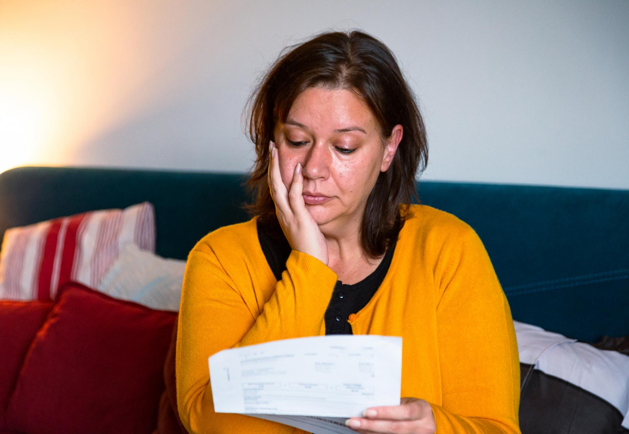 Woman looking sullenly at a bill